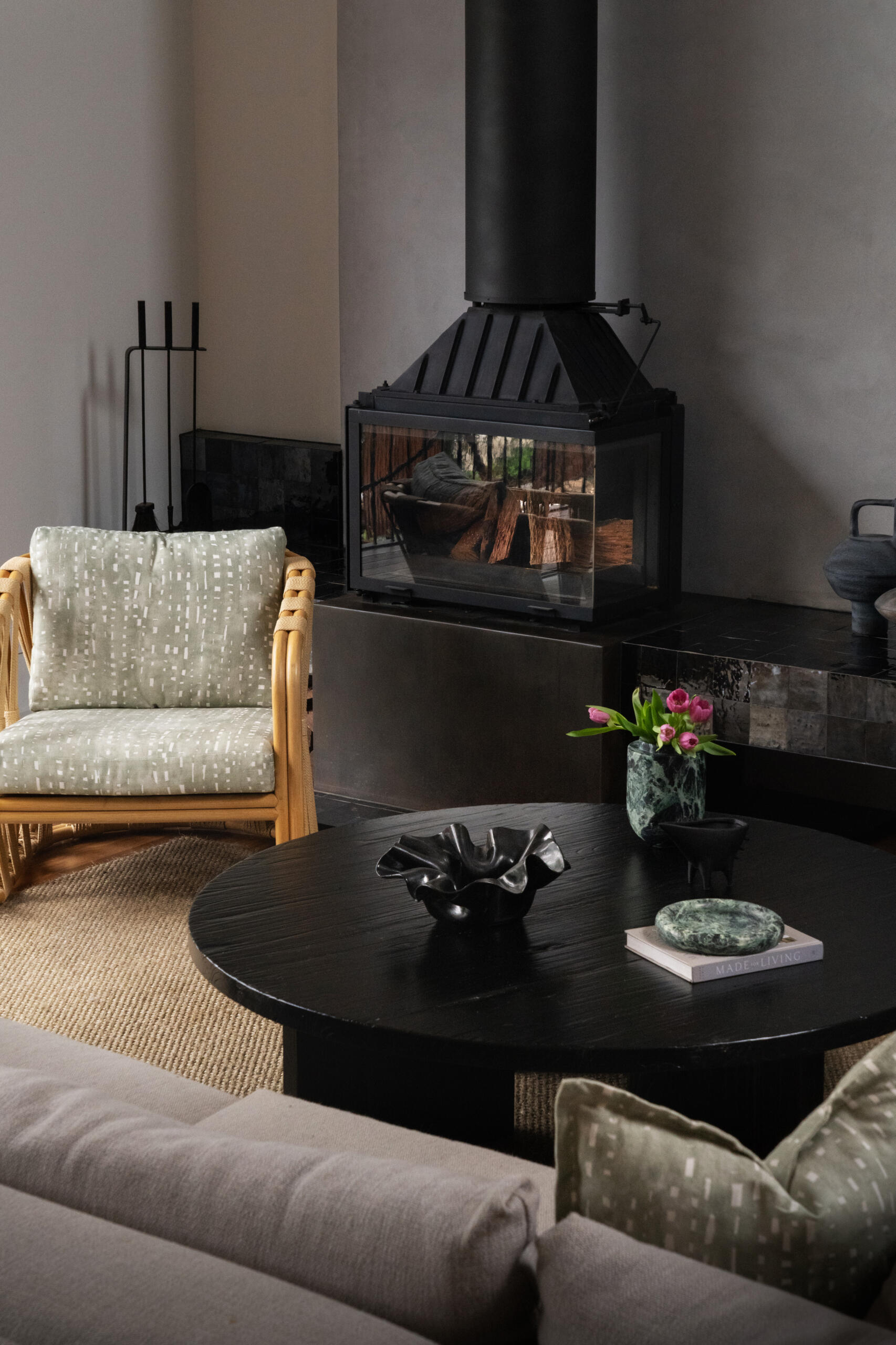 A light-filled living room opening to the outdoors has warm timber tones, a fireplace, and handcrafted finishes that invite relaxation and connection.