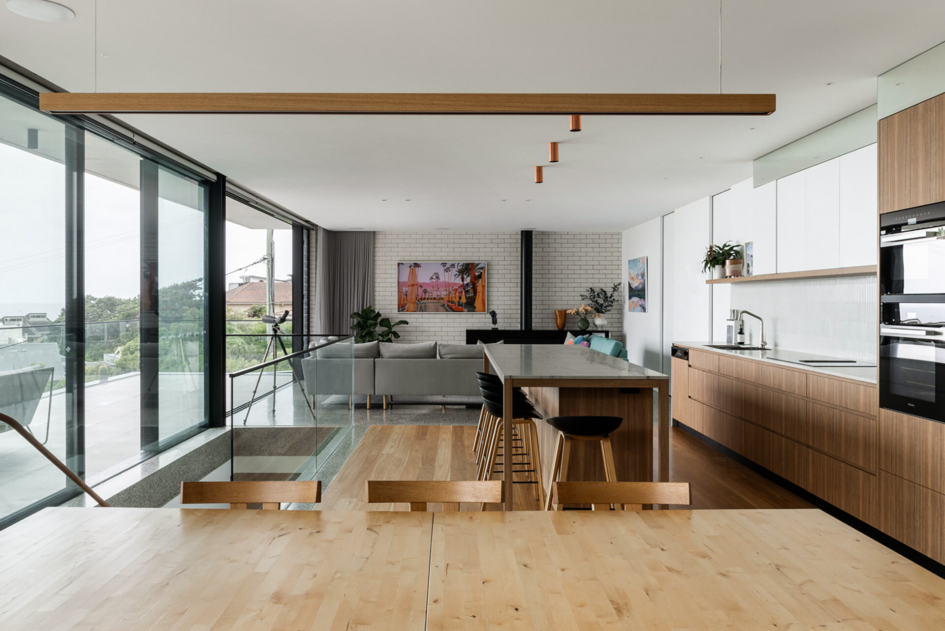 On the main level of this modern home, floor-to-ceiling glazing wraps the open-plan living, dining, and kitchen zone. This level connects directly to both the garden and the beach-facing terrace, blurring indoor and outdoor living. Designed for entertaining and everyday comfort, it’s all about flow, light, and uninterrupted views.