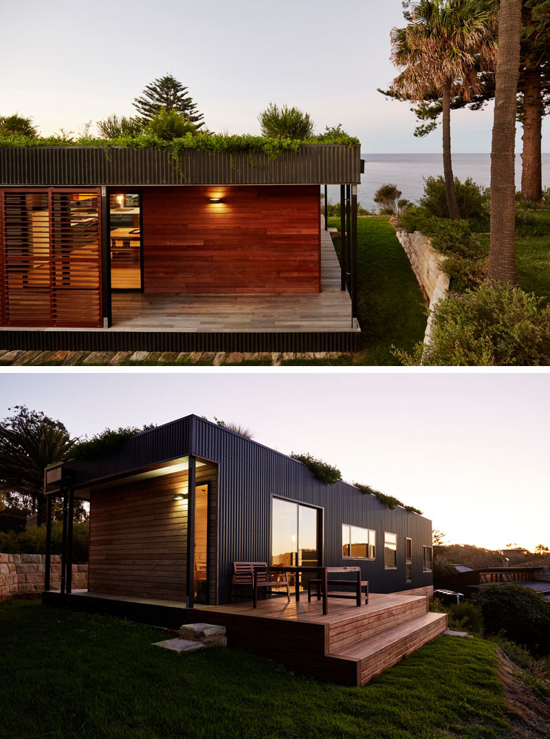 A modern 2 bedroom prefab house with a green roof and wraparound deck.