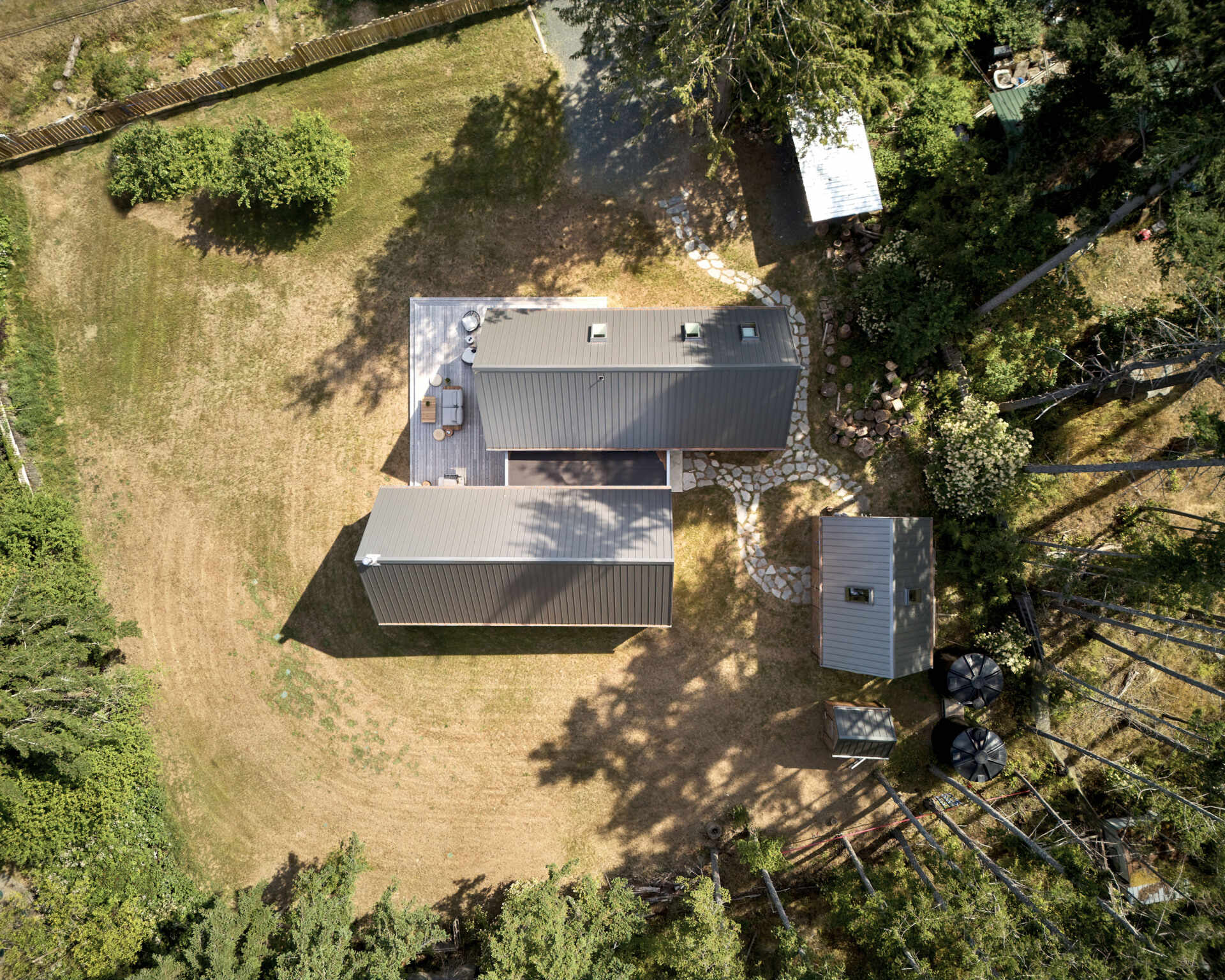 The exterior of this modern cabin is clad in natural cedar shingles, giving the modern form a timeless texture that resonates with the forest surroundings.