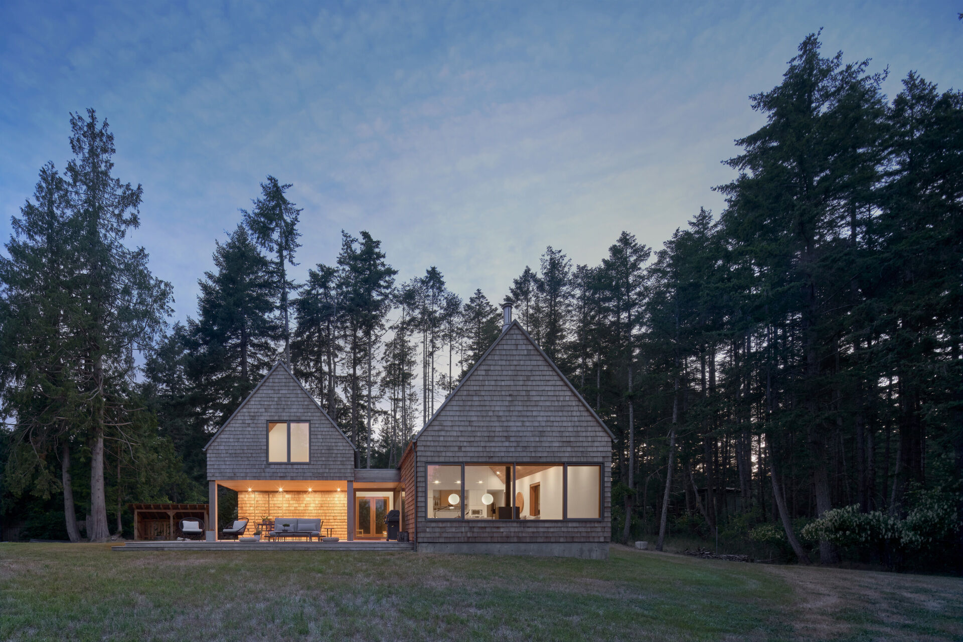 When illuminated from within, theis cabin’s expansive glass surfaces cast a soft glow through the forest, creating a warm beacon among the trees while maintaining its modern character.