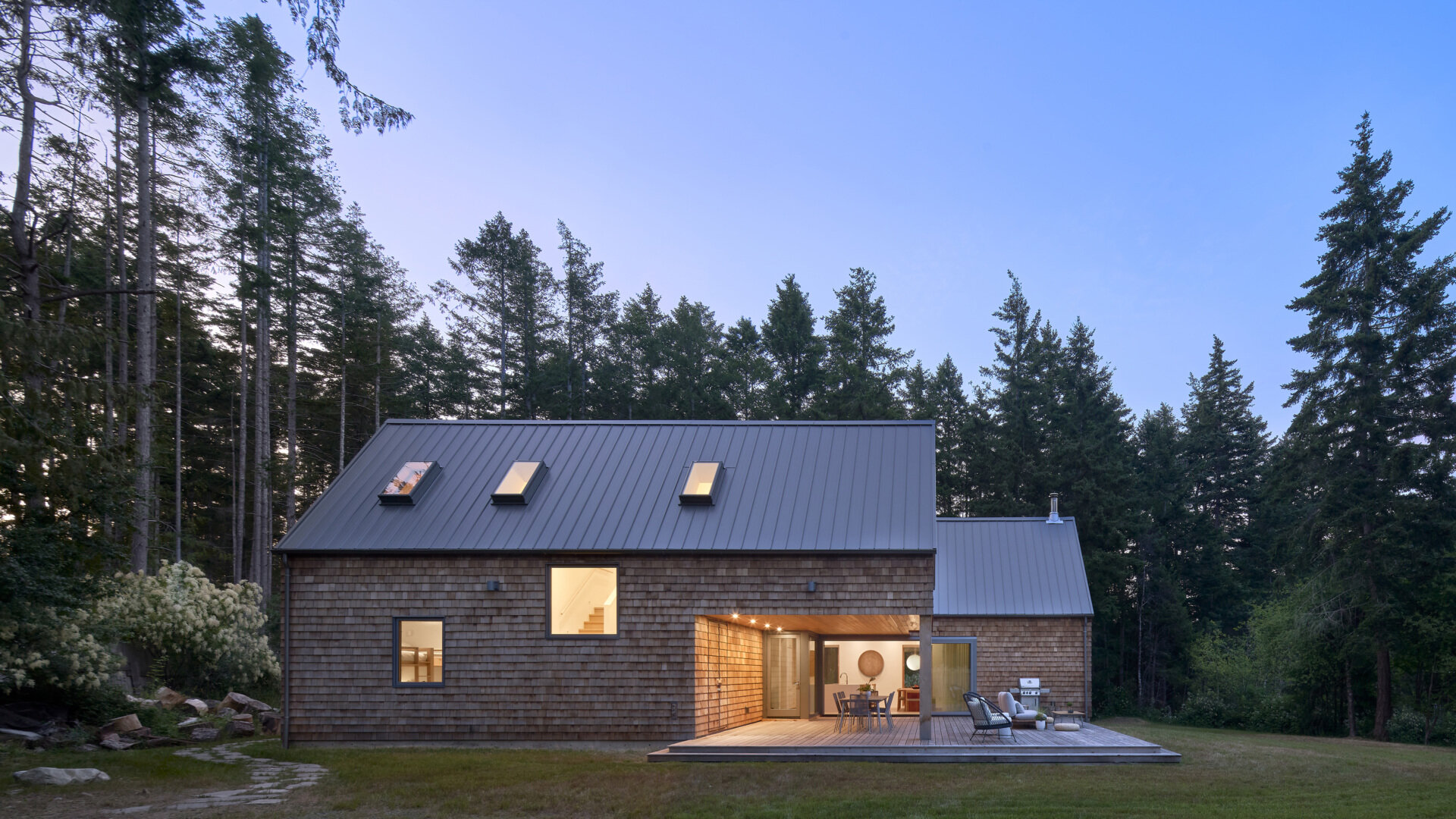 When illuminated from within, theis cabin’s expansive glass surfaces cast a soft glow through the forest, creating a warm beacon among the trees while maintaining its modern character.