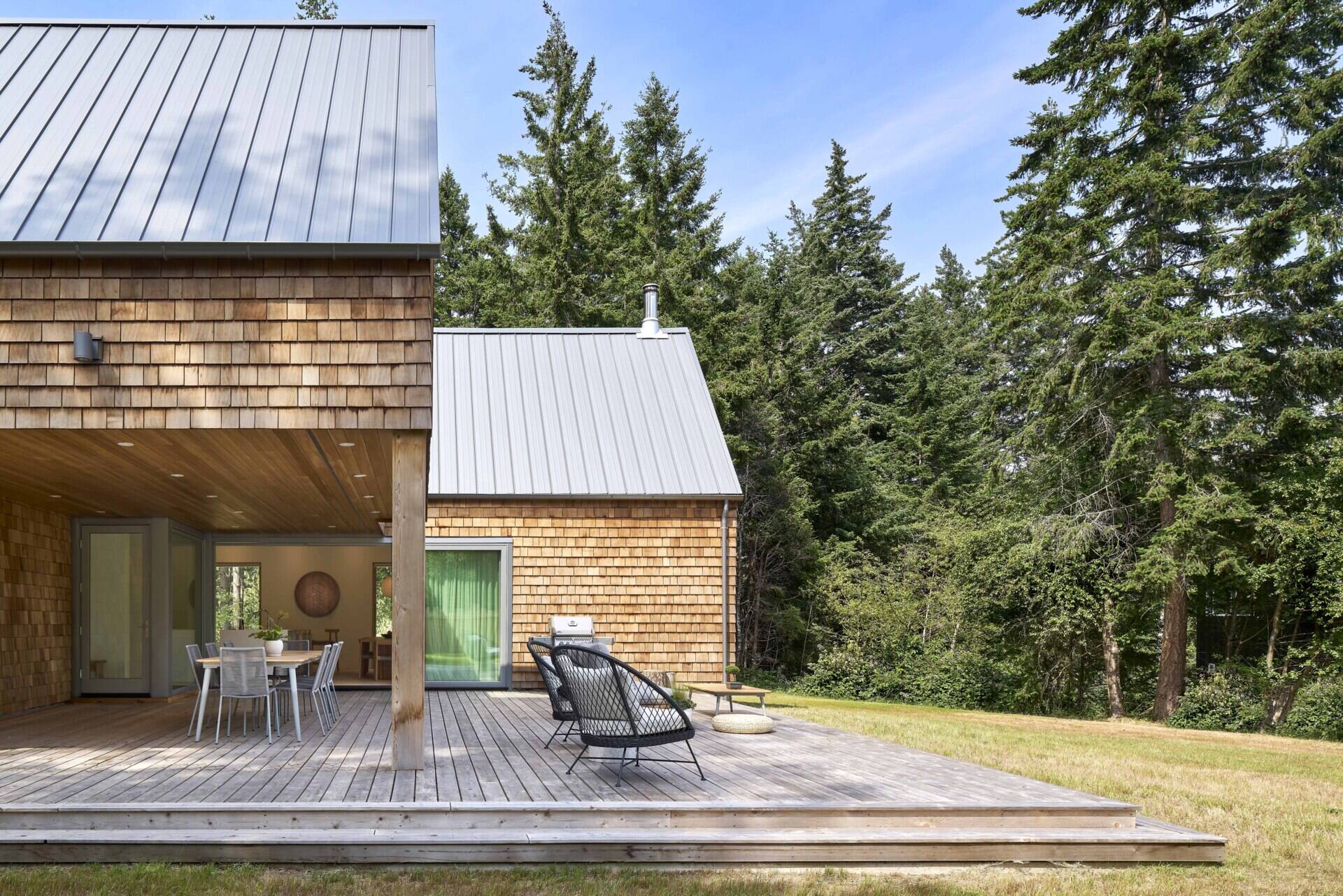 An partially covered deck extends the living spaces directly into the woodland, blurring the boundary between interior and exterior. These spaces enhance the home’s dialogue with nature while providing areas for relaxation and gathering.