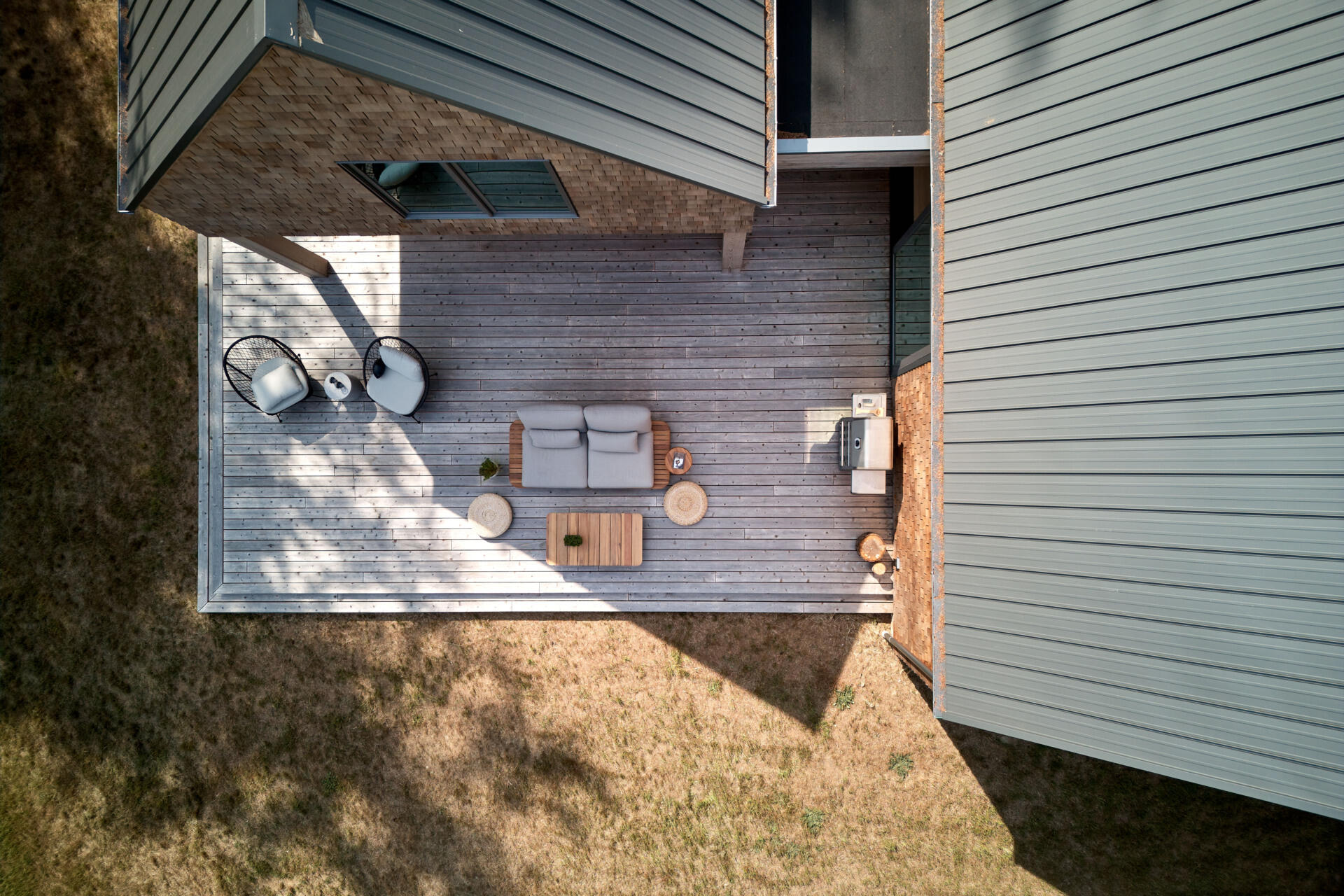 An partially covered deck extends the living spaces directly into the woodland, blurring the boundary between interior and exterior. These spaces enhance the home’s dialogue with nature while providing areas for relaxation and gathering.