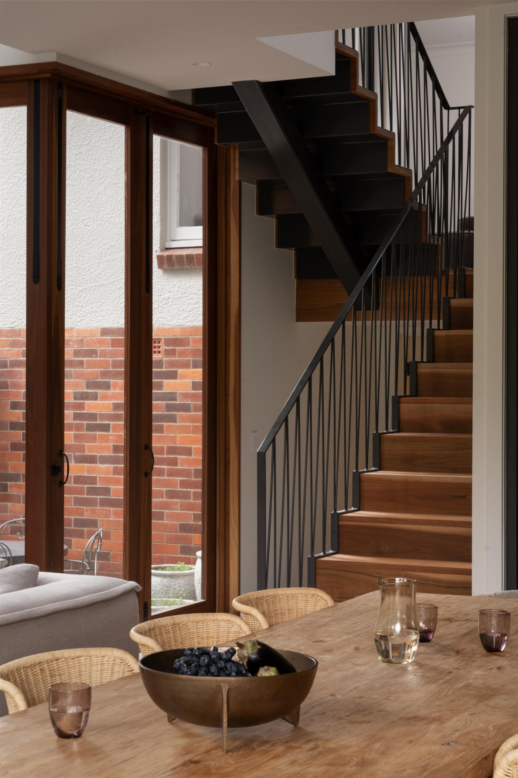 The central staircase isn’t just a circulation point, it plays a role in the home’s natural ventilation strategy. Acting as a vertical channel, it allows cool breezes to move through the interior, helping the home stay comfortable without relying heavily on mechanical cooling.