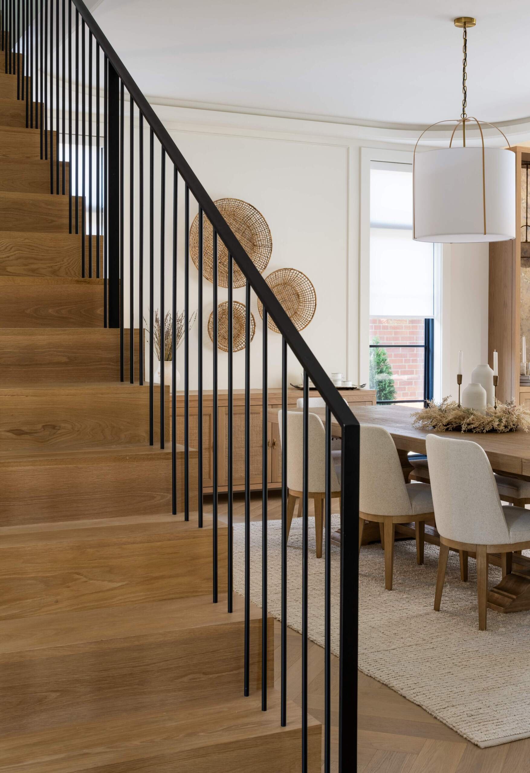 This staircase breaks from convention by not stacking directly between levels. Instead, its discreet placement allows for a more flexible layout. The semi-circular floor opening above gives it presence without overwhelming the interiors.