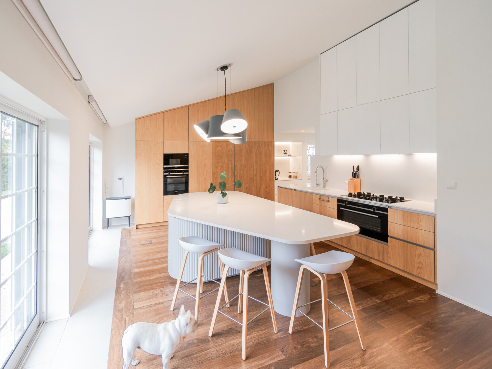 Minimalist wood cabinetry, a sculptural ribbed island, and soft curves define this contemporary kitchen renovation. Natural textures and original timber floors bring warmth, while the curved forms add movement and balance to the clean, modern layout.