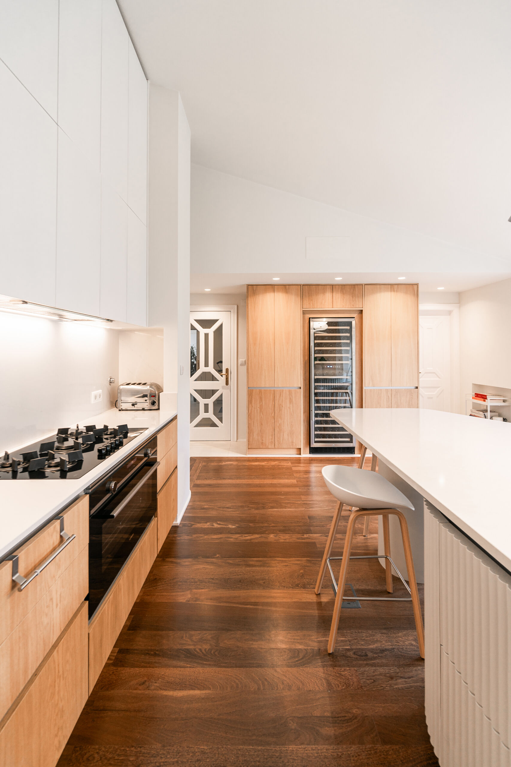 Minimalist wood cabinetry, a sculptural ribbed island, and soft curves define this contemporary kitchen renovation. Natural textures and original timber floors bring warmth, while the curved forms add movement and balance to the clean, modern layout.
