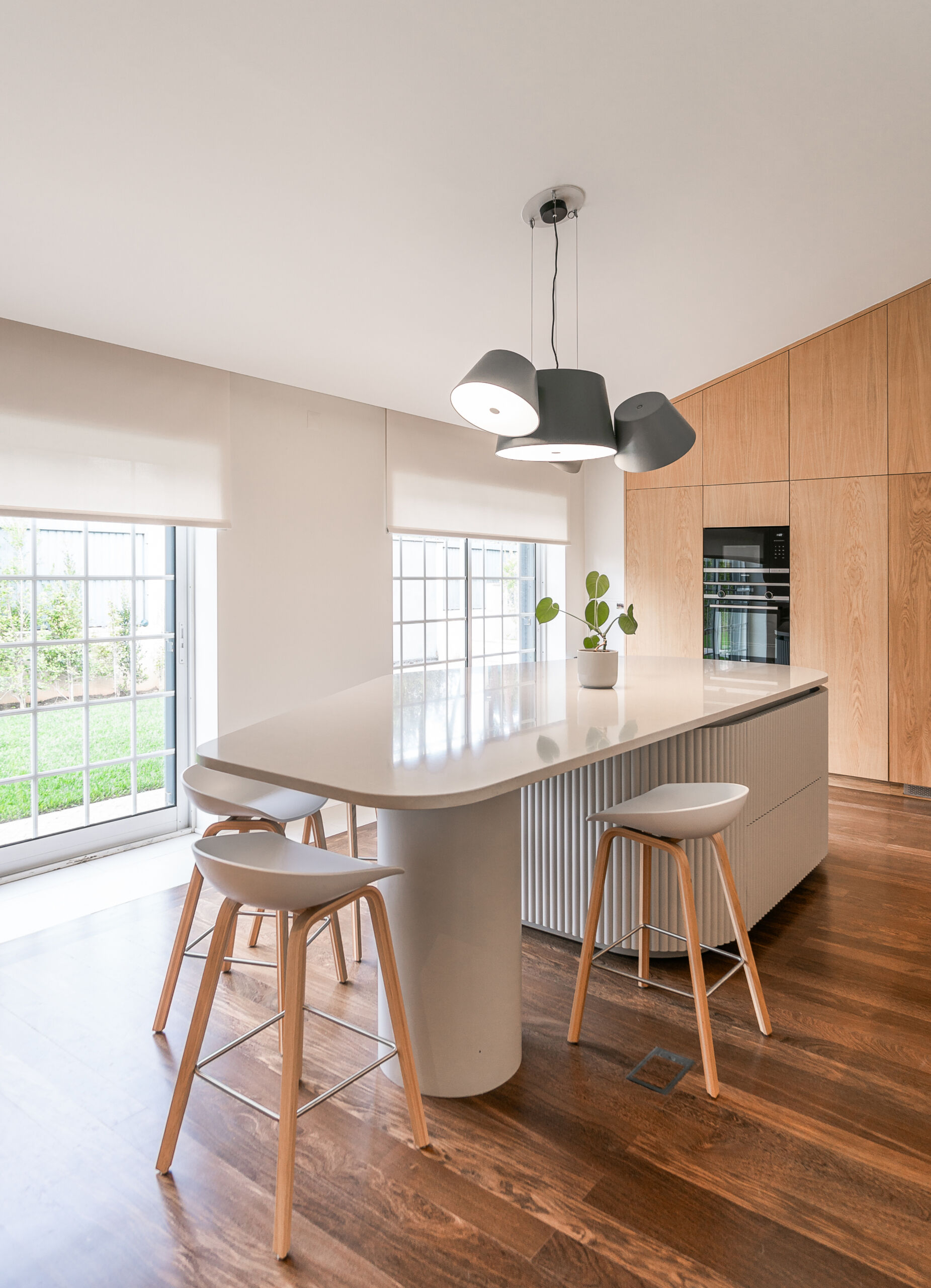 Minimalist wood cabinetry, a sculptural ribbed island, and soft curves define this contemporary kitchen renovation. Natural textures and original timber floors bring warmth, while the curved forms add movement and balance to the clean, modern layout.