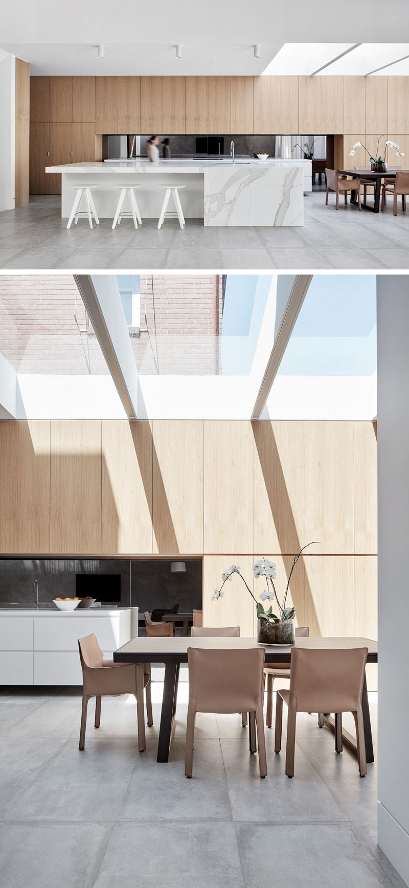 The kitchen contrasts with lighter wood and pale stone, with a skylight filling the dining area with natural light.