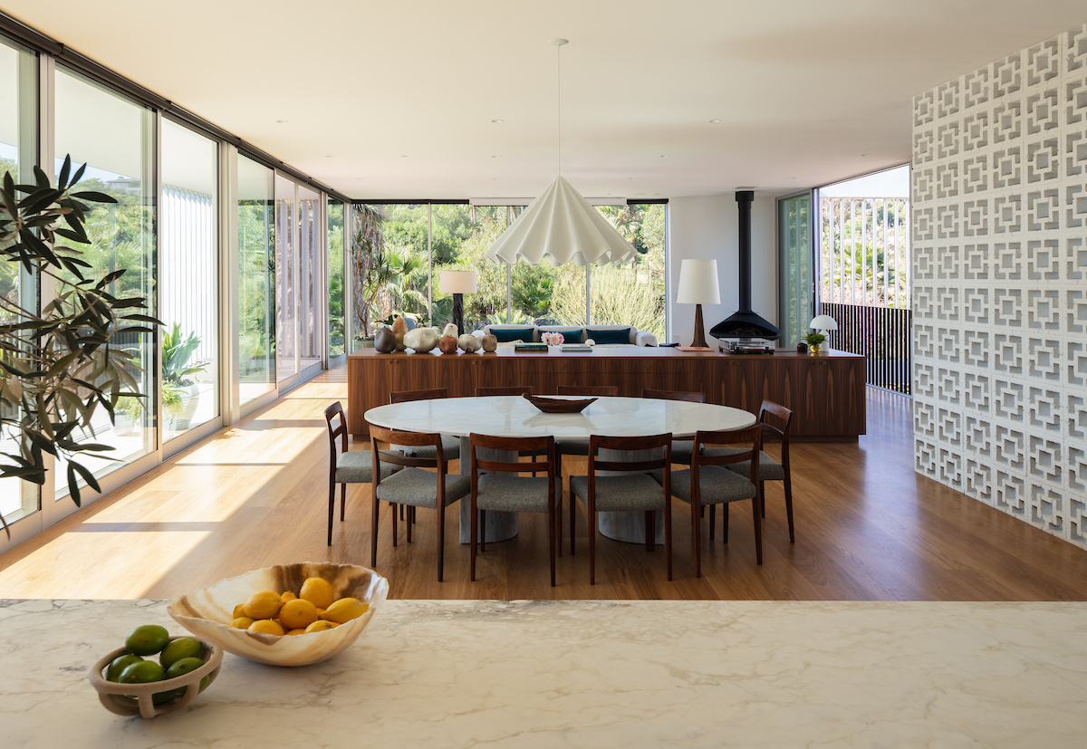 Adjacent to the living room, the dining area features an oval dining table, while nearby sliding doors open to a balcony. Elevated views enhance the sense of openness, making this area of the home perfect for everyday use and entertaining.