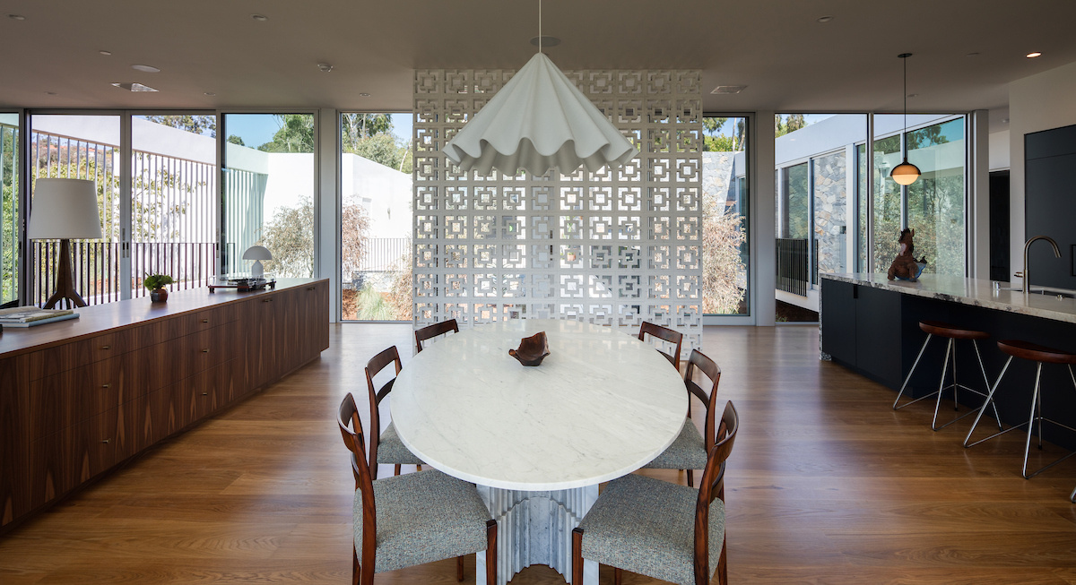Adjacent to the living room, the dining area features an oval dining table, while nearby sliding doors open to a balcony. Elevated views enhance the sense of openness, making this area of the home perfect for everyday use and entertaining.