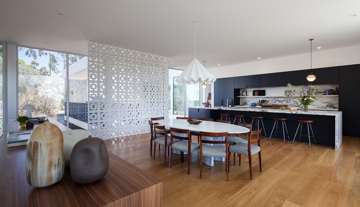 Adjacent to the living room, the dining area features an oval dining table, while nearby sliding doors open to a balcony. Elevated views enhance the sense of openness, making this area of the home perfect for everyday use and entertaining.