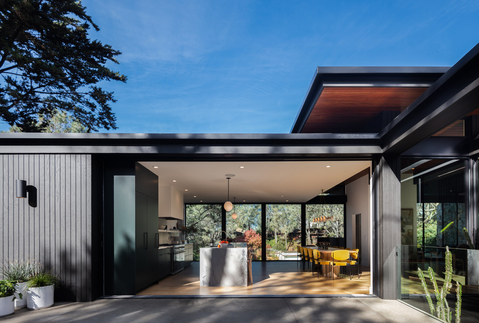 Retractable glass walls open wide, erasing any barrier between interior spaces and the surrounding landscape. They provide natural ventilation while reinforcing the home’s indoor-outdoor lifestyle.
