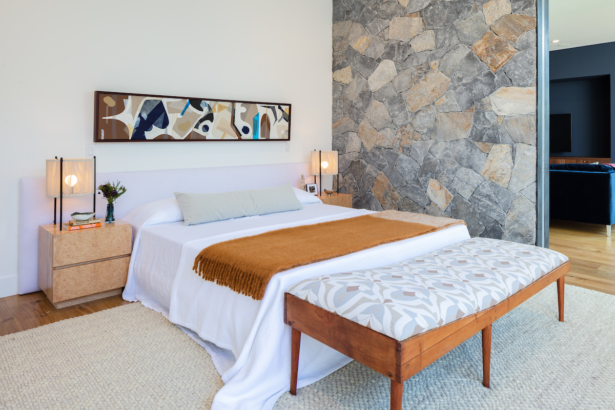 A bedroom just off the media room features a stone accent wall that brings a natural touch to the space.