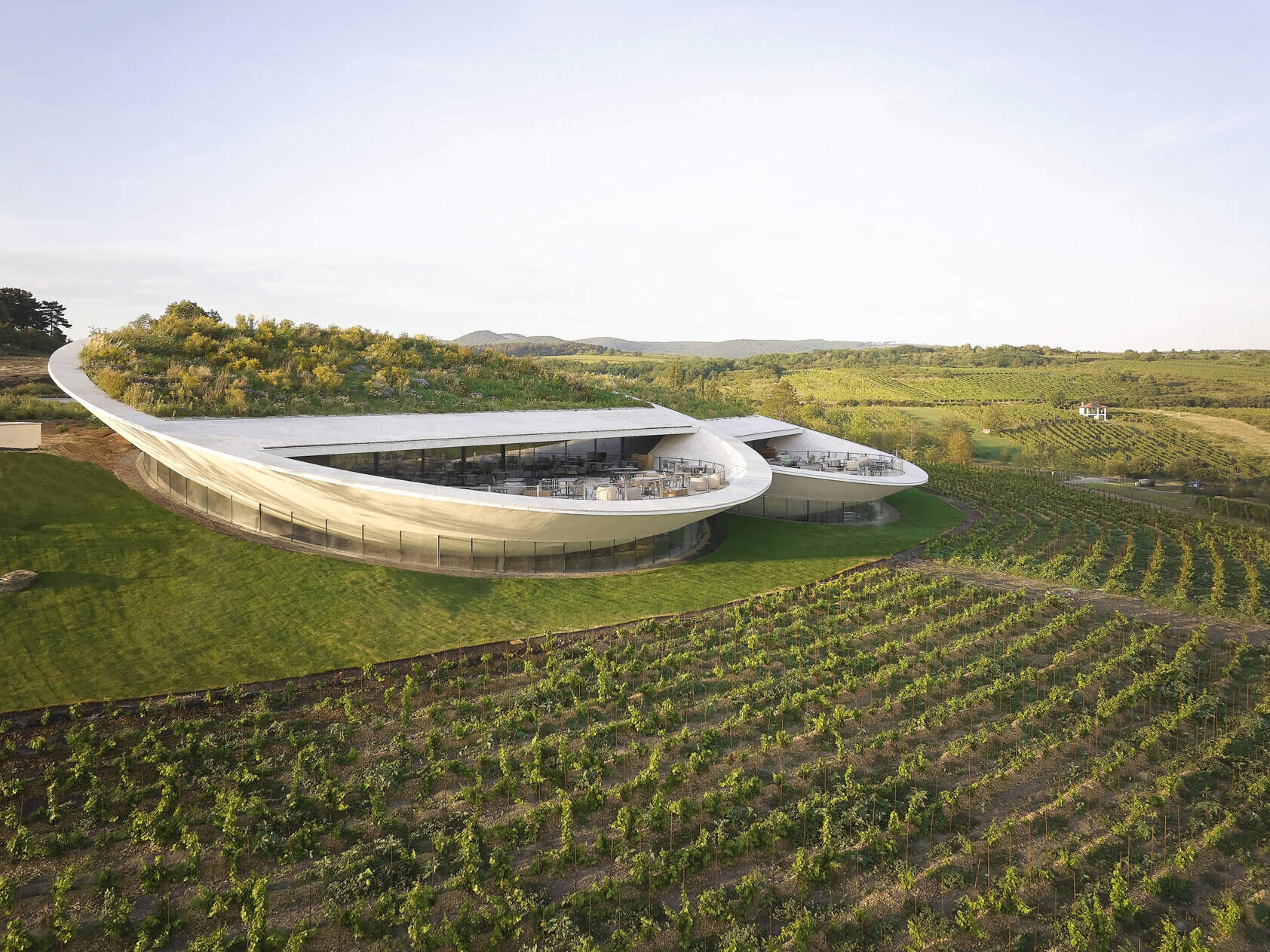 The winery’s lens-shaped floating volumes create a striking landmark, balancing dramatic design with functional underground fermentation and storage areas.