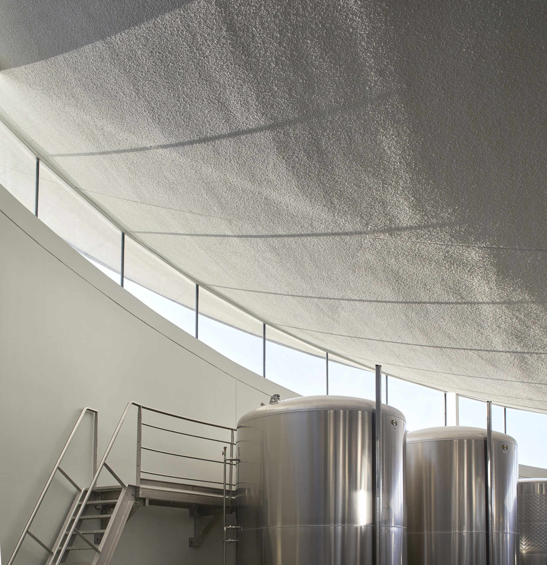 Underground fermentation, bottling, and storage areas ensure efficient winemaking, with a sleek, metallic aesthetic contrasting the warm, inviting visitor spaces above.