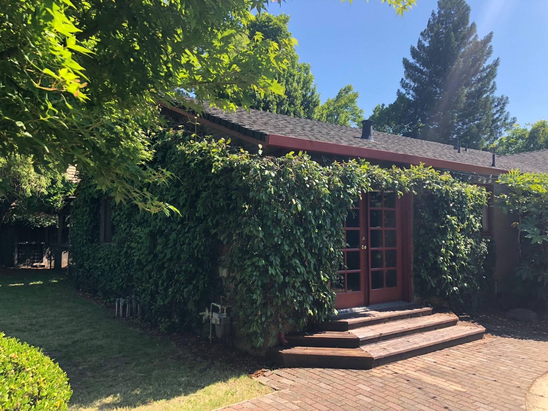 BEFORE - The original 1970s home had beige brick exteriors covered with ivy, creating a dated look.