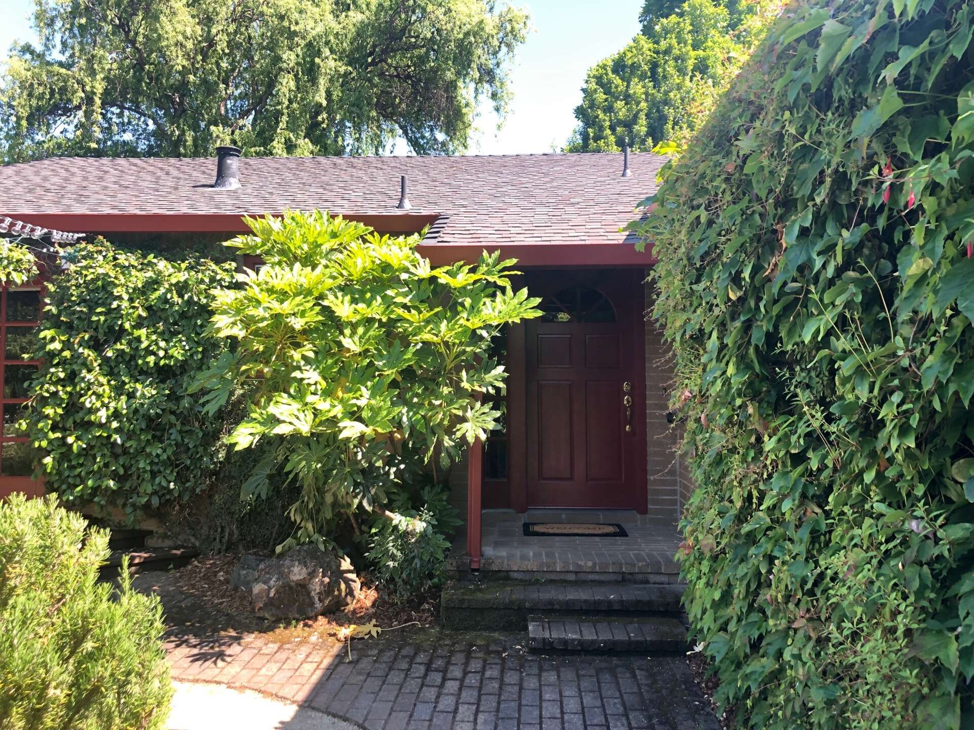 BEFORE - The original 1970s home had beige brick exteriors covered with ivy, creating a dated look.