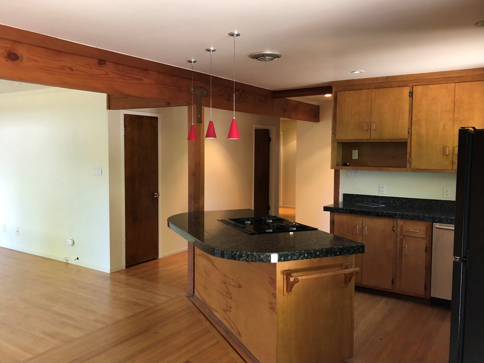 BEFORE - The interiors of the original 1970s home felt outdated and closed off. Low, flat ceilings made the rooms feel compressed, while small openings limited both natural light and views of the surrounding garden. 