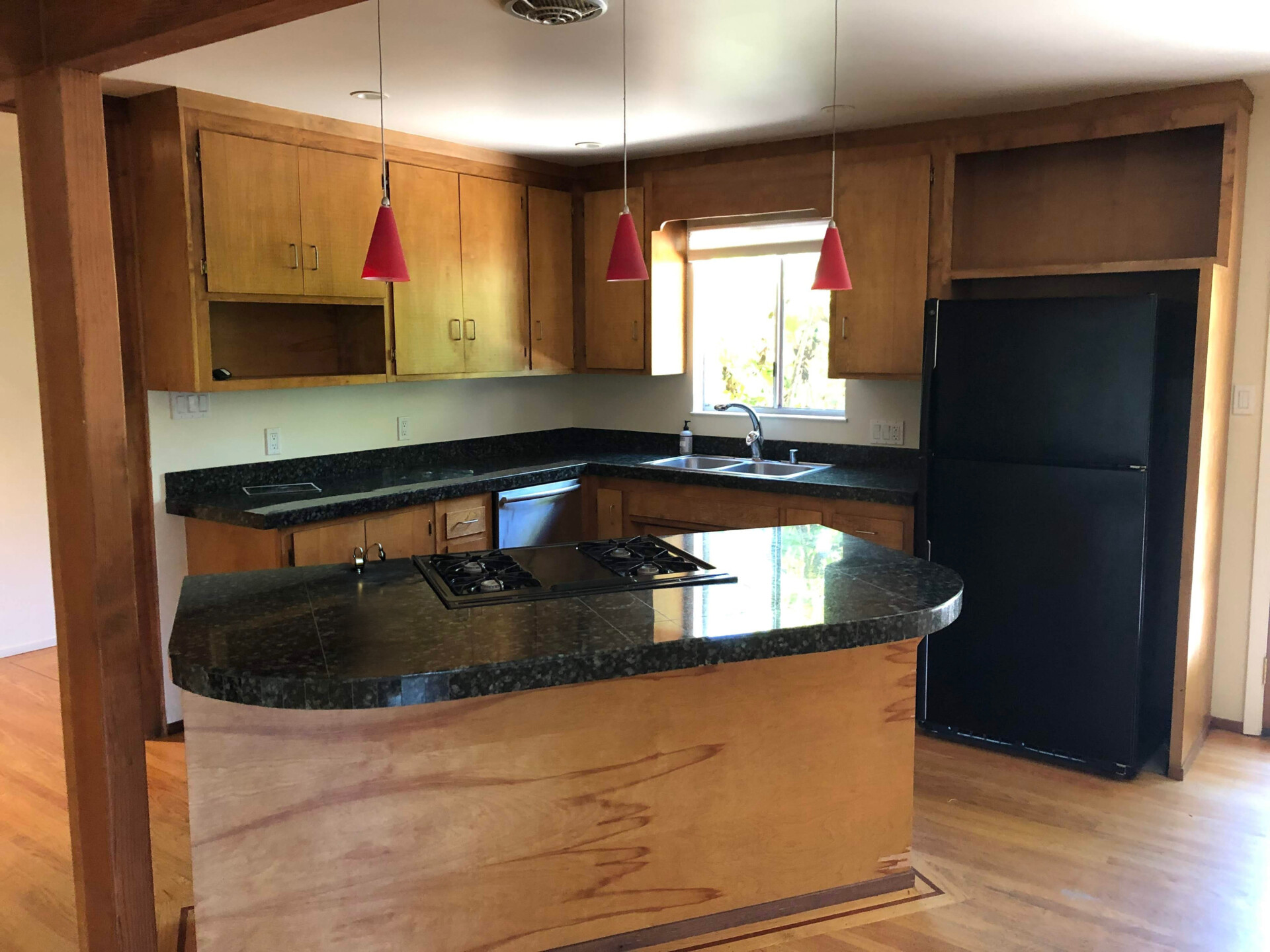 BEFORE - The interiors of the original 1970s home felt outdated and closed off. Low, flat ceilings made the rooms feel compressed, while small openings limited both natural light and views of the surrounding garden. 