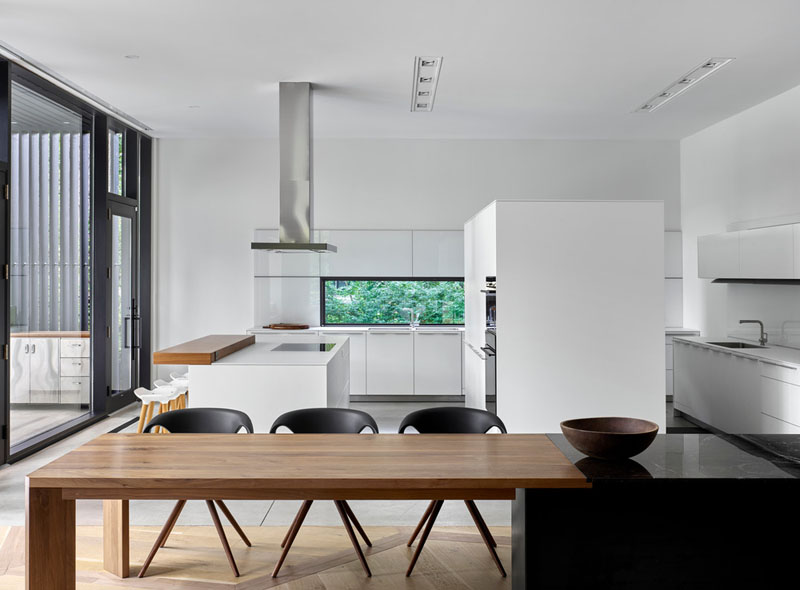 This kitchen channels the look of a showroom with its clean white finishes and sleek lines. This space contrasts with the heritage architecture, but still feels tied together through its simplicity and lightness.