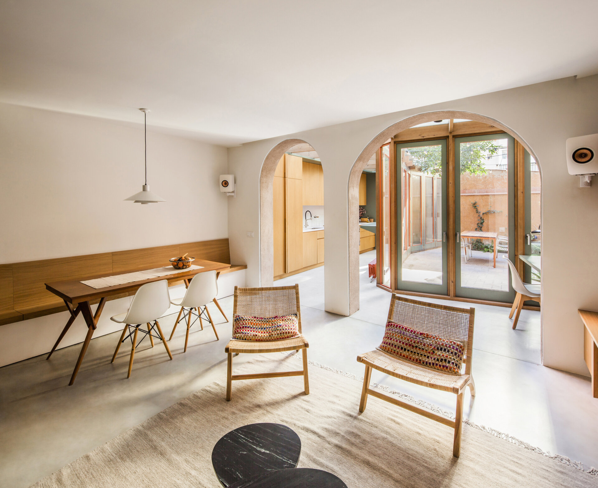 The reconfigured ground floor includes a dining area with a built-in banquette and cabinet with shelving. Its placement maximizes space while keeping the area in direct dialogue with the patio and the other social spaces.