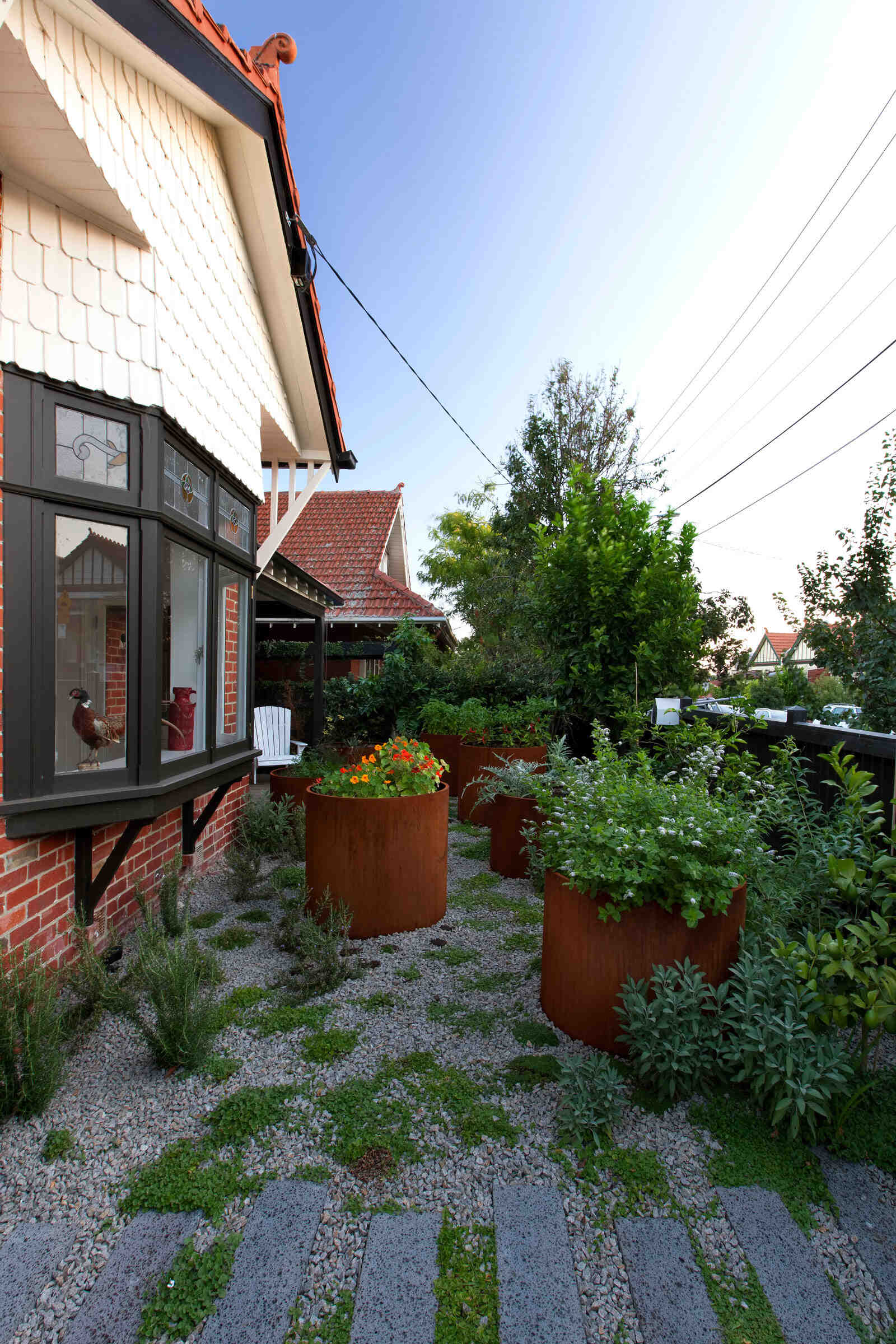 A serene garden path guides visitors down the side of the Edwardian cottage, leading to the backyard extension.