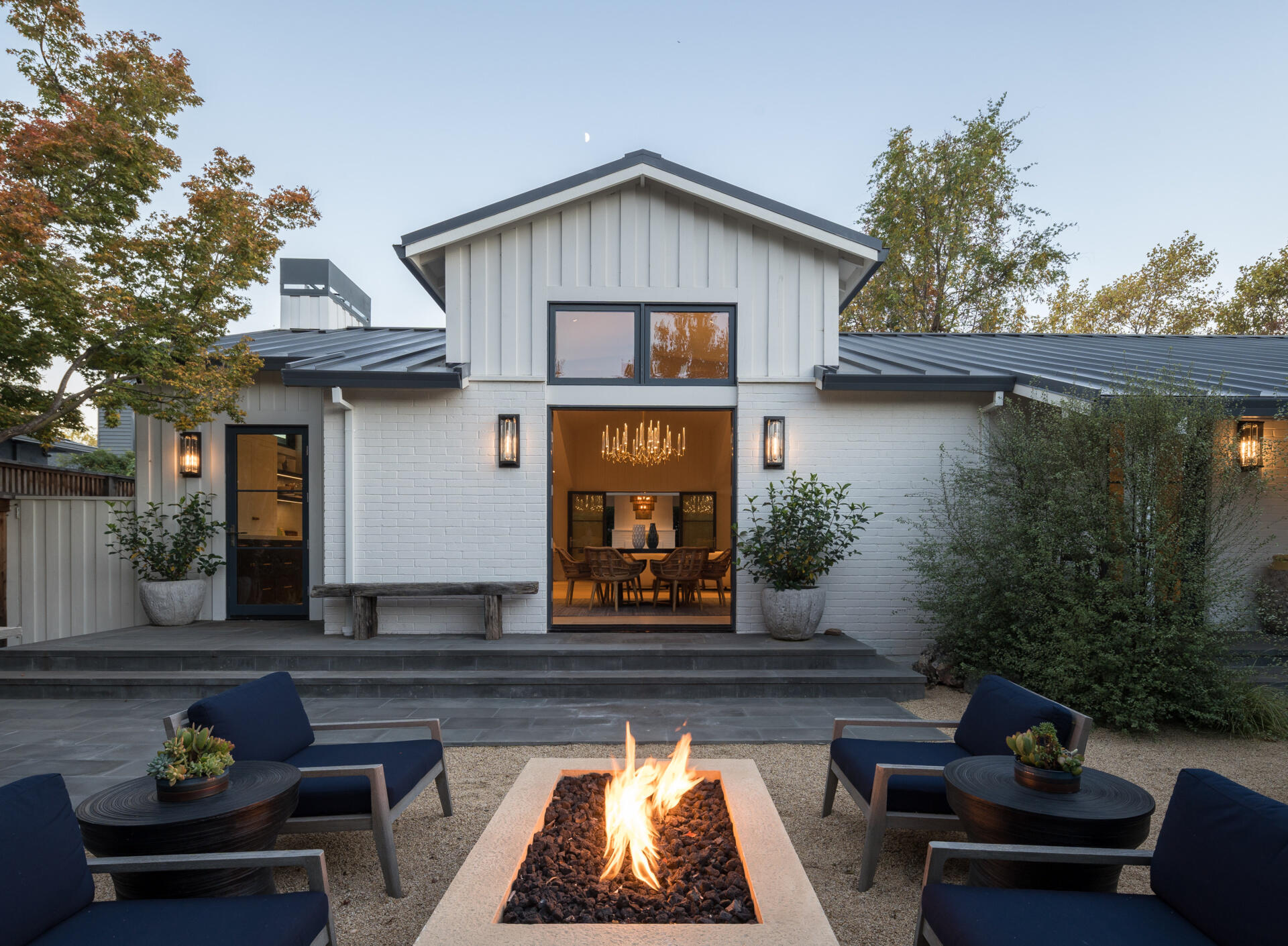 A renovated 1970s house has two outdoor areas with fireplaces.