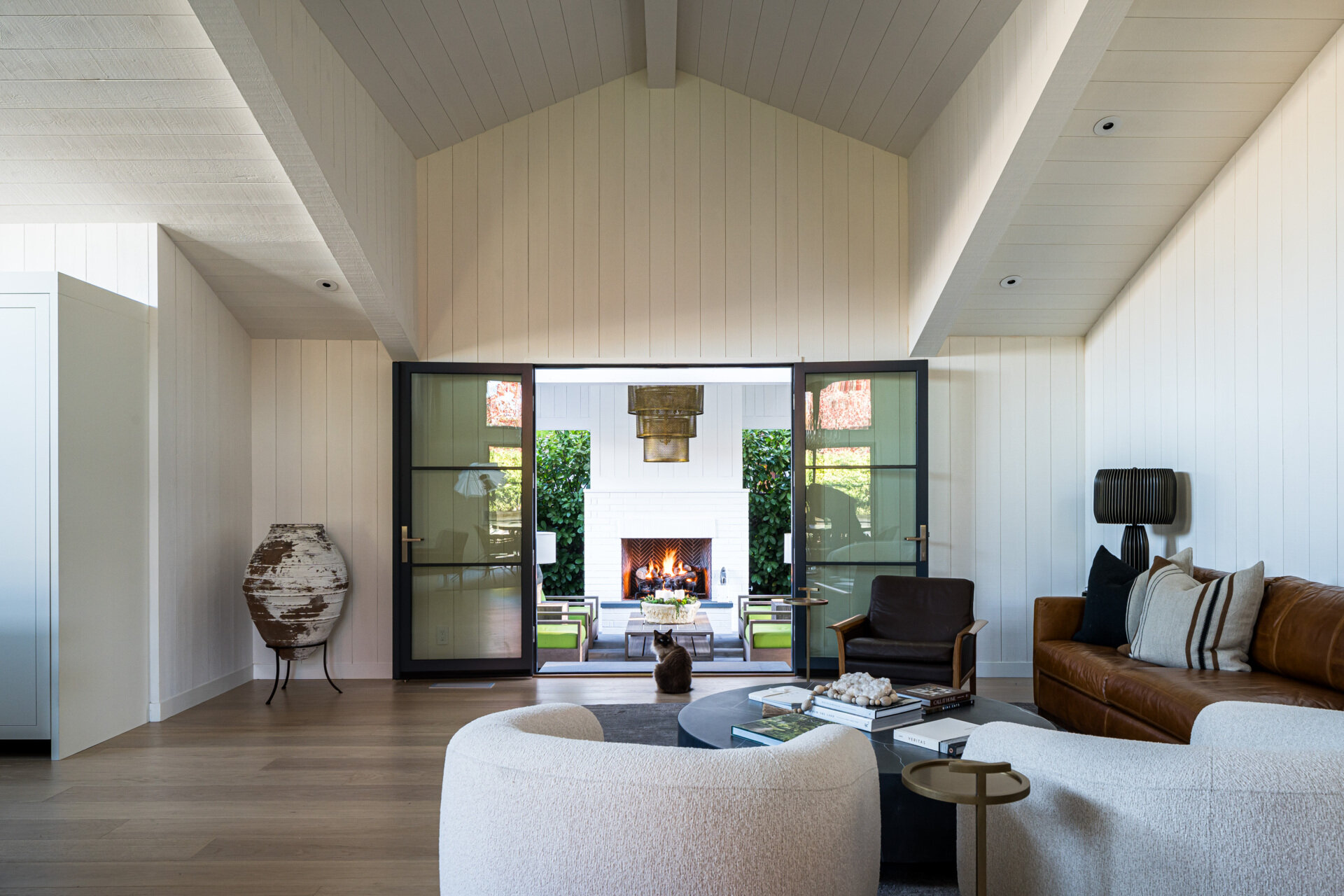 This remodeled living room was expanded and infused with natural light. By lifting the ceiling and connecting it visually with the garden, the space now feels open and vibrant. A triangular window on the western wall adds a unique detail, framing unexpected views of the surrounding hills.