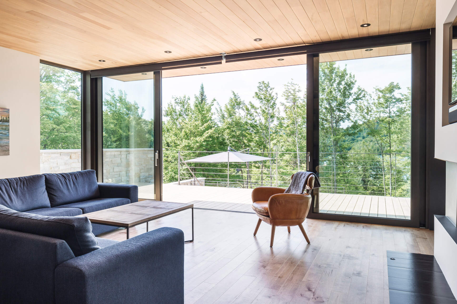 A double-sided fireplace, custom TV cut-out, and floor-to-ceiling bookshelf make this living room both sleek and cozy.