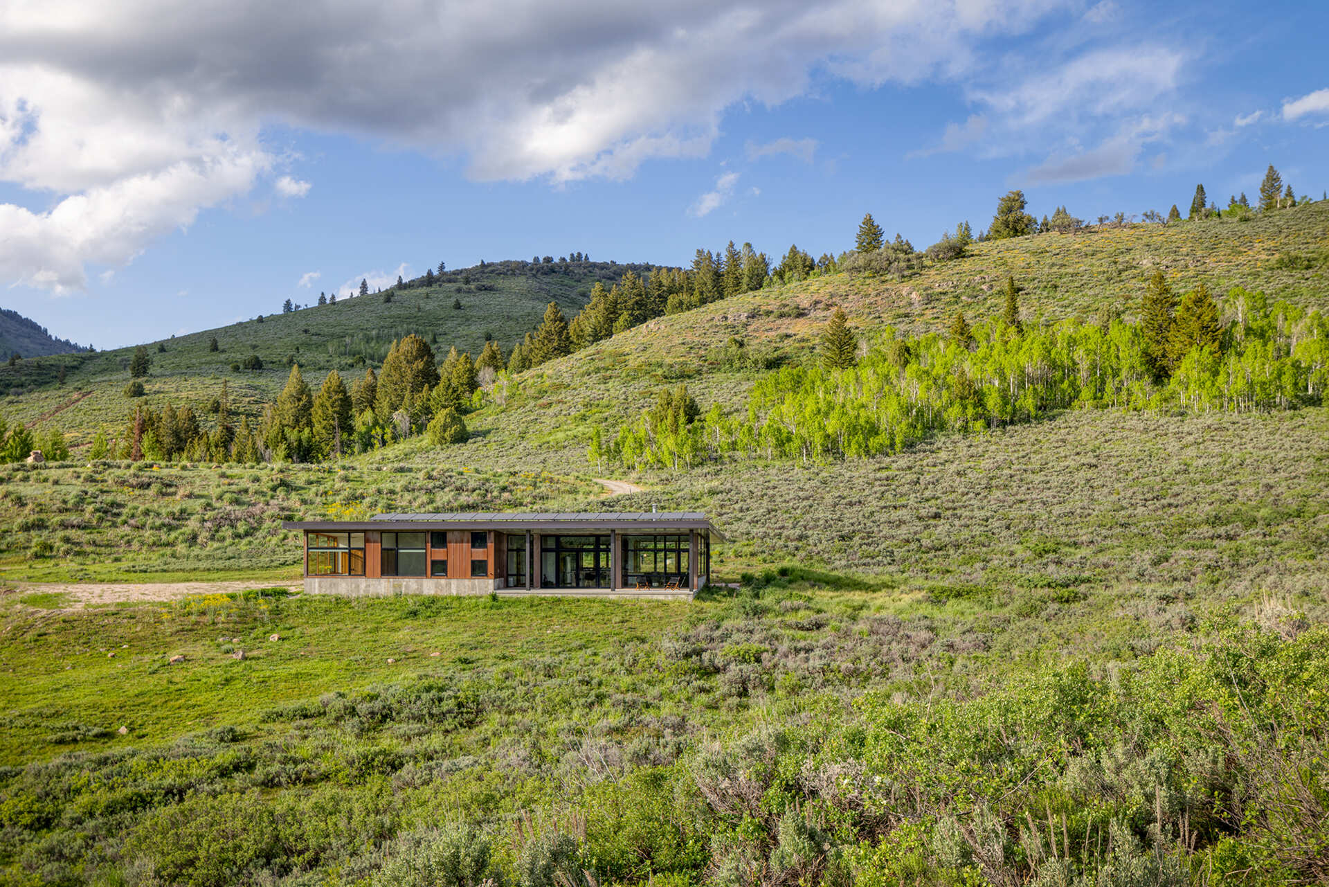 Weathering steel siding, concrete, and a snow-ready metal roof give this off-grid cabin durability while blending into its Utah setting.