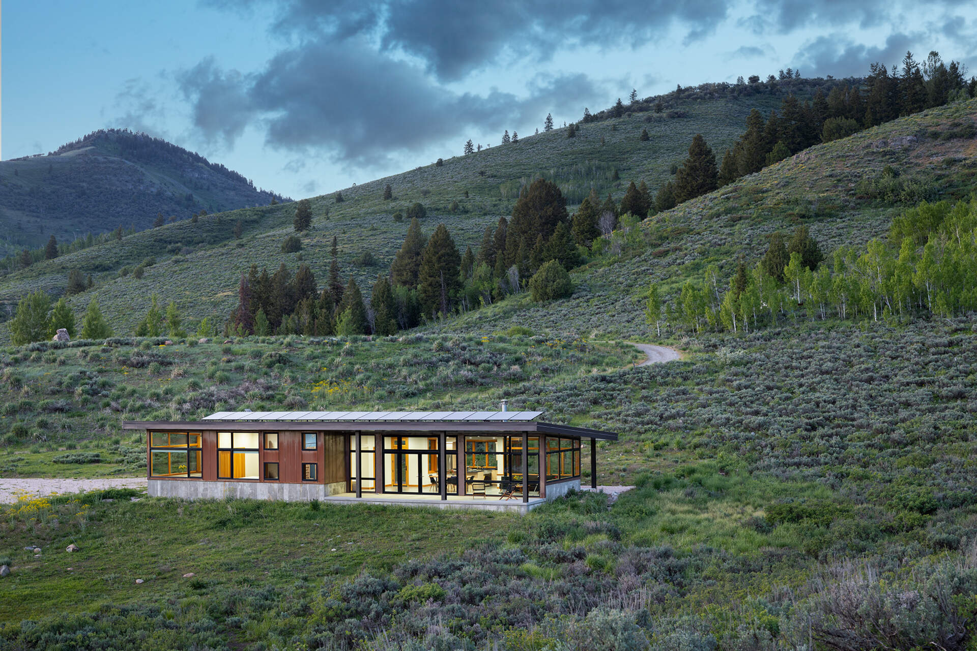 Weathering steel siding, concrete, and a snow-ready metal roof give this off-grid cabin durability while blending into its Utah setting.