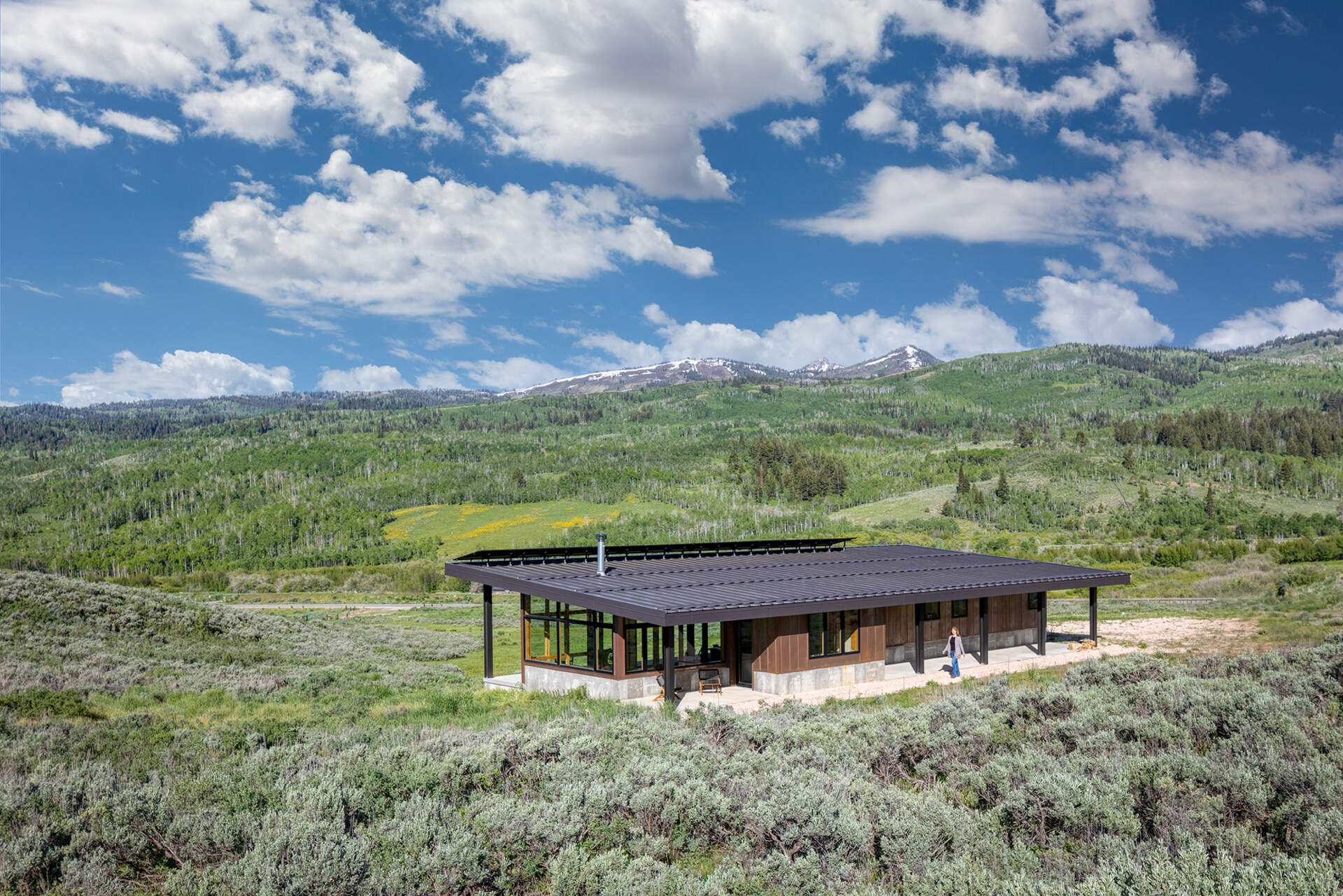 Weathering steel siding, concrete, and a snow-ready metal roof give this off-grid cabin durability while blending into its Utah setting.