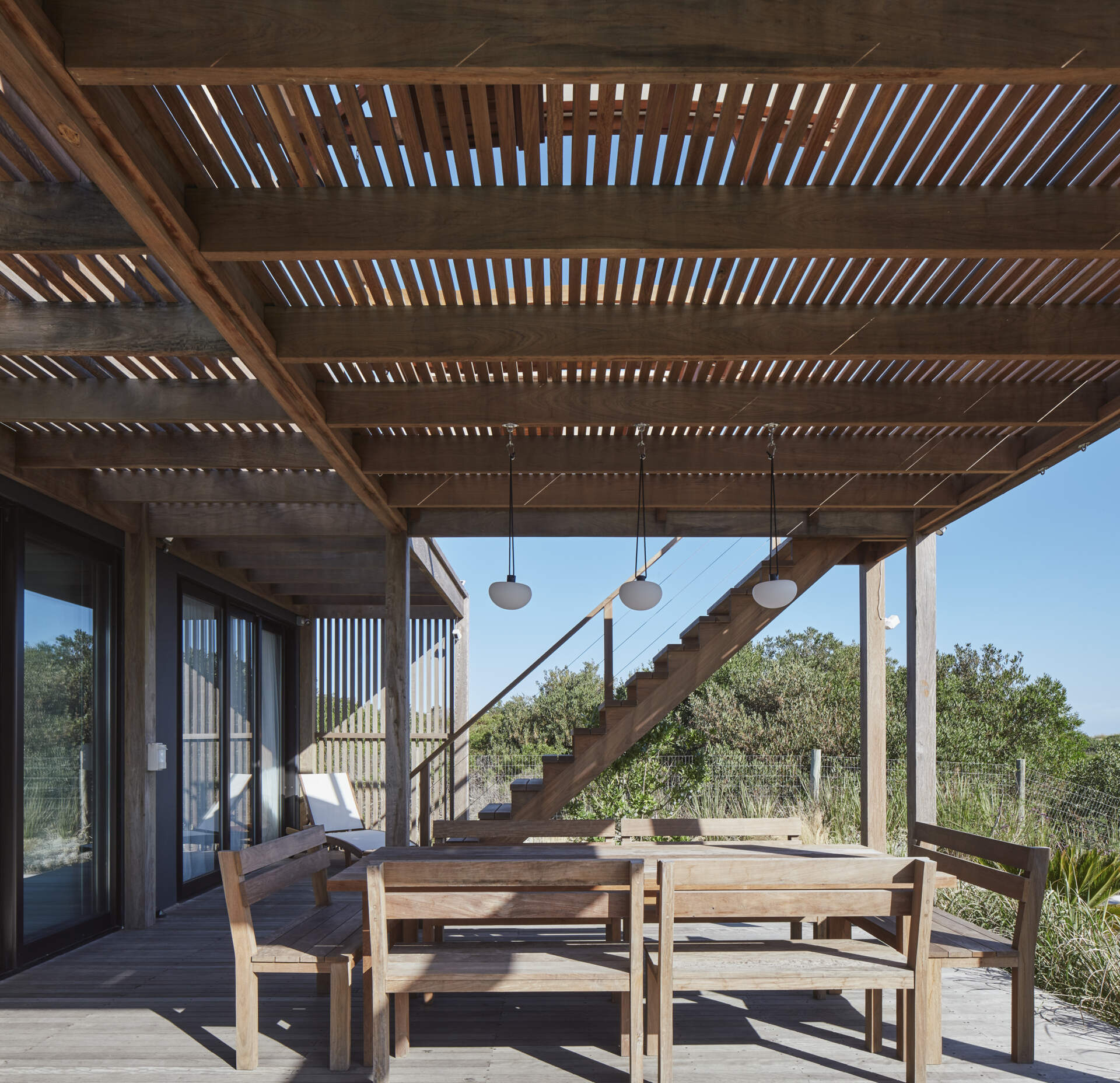 Sliding doors open to connect the kitchen with a covered outdoor dining area.