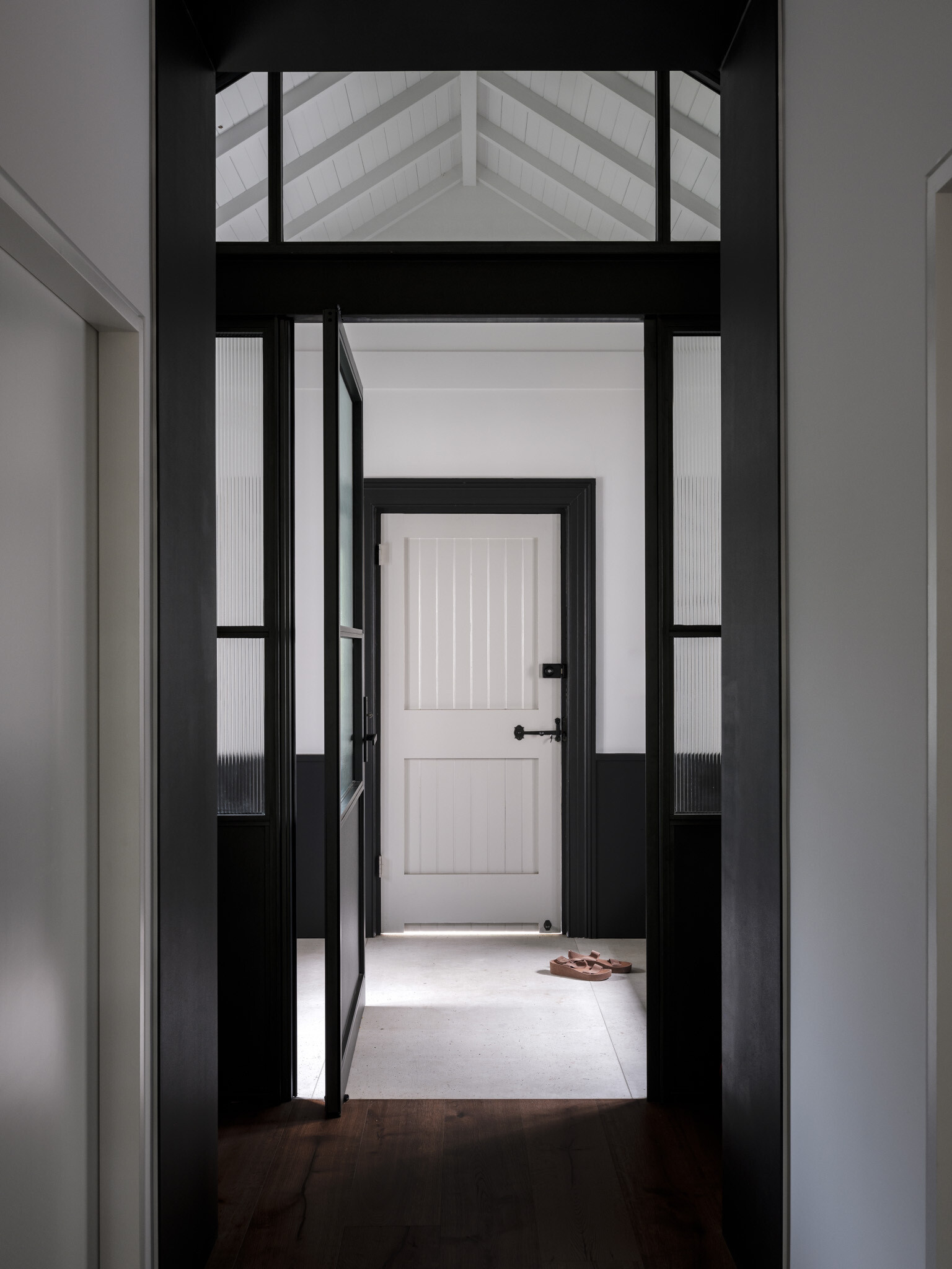 The vestibule acts as a threshold between eras. Here, the design does not attempt to erase history but instead highlights the transition, allowing heritage masonry to stand beside refined steel framing and new openings. This sense of passage sets the tone for the house as a whole.