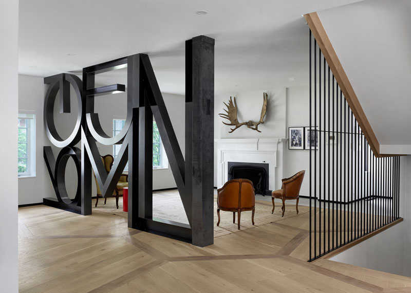 The formal living room sets the tone for the home’s mix of old and new. Here, a word art installation by Commute Design makes a bold statement, while a curated collection of vintage chairs reflects the homeowners’ passion for collecting.