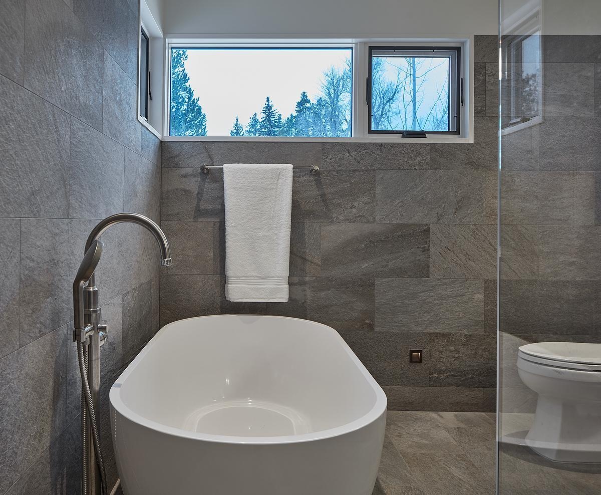 A modern bathroom with grey tiles in a guest house.