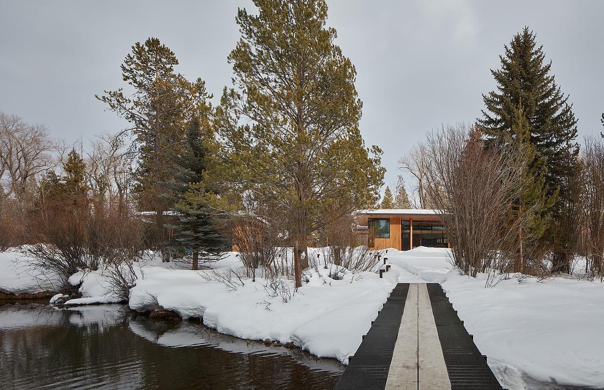 A modern guest house and garage added to a log cabin.