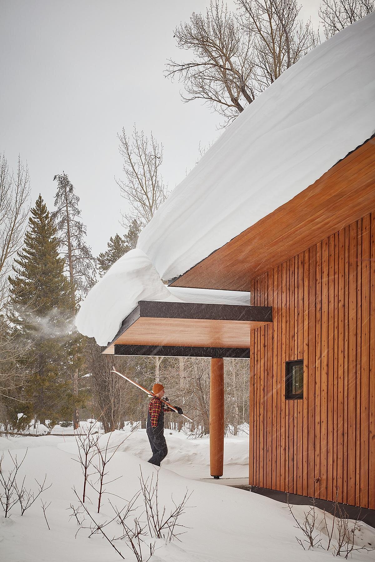 A modern guest house and garage added to a log cabin.