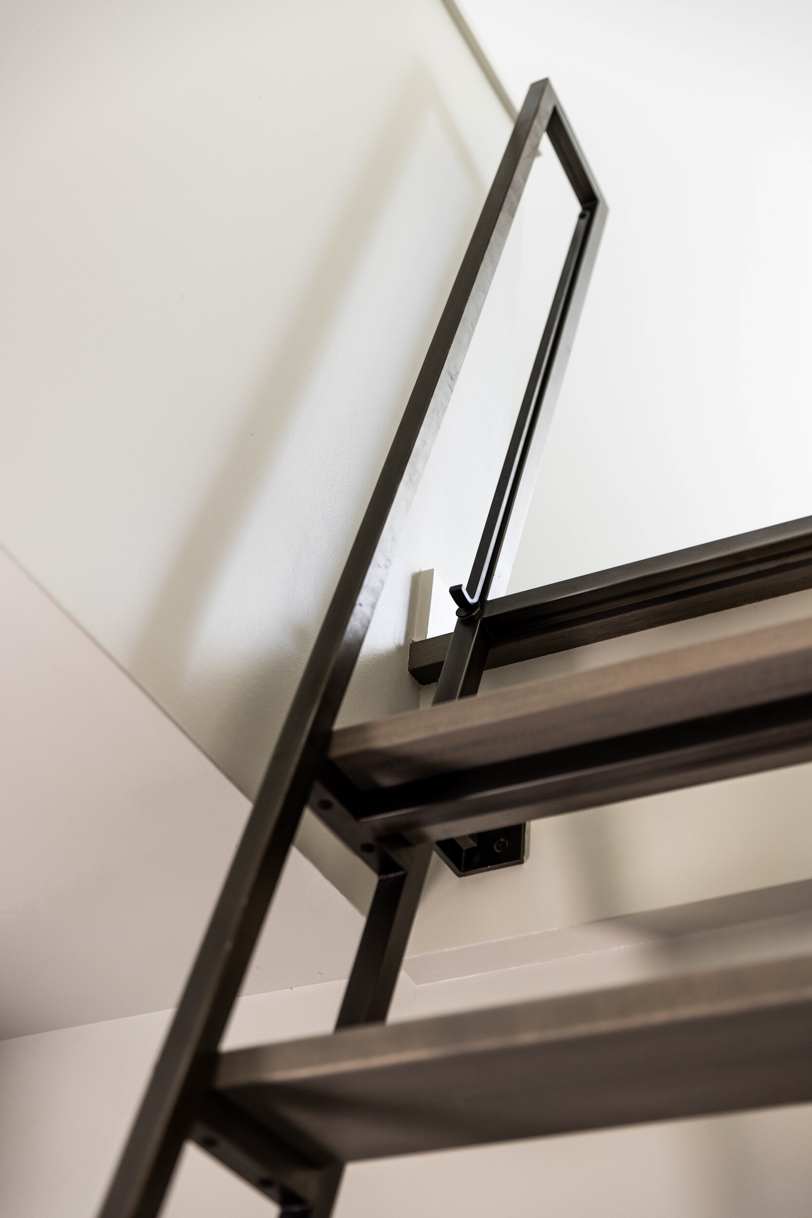 Custom steel ladder leading to a loft that doubles as office and extra sleeping space, adding flexibility for family gatherings and entertaining.