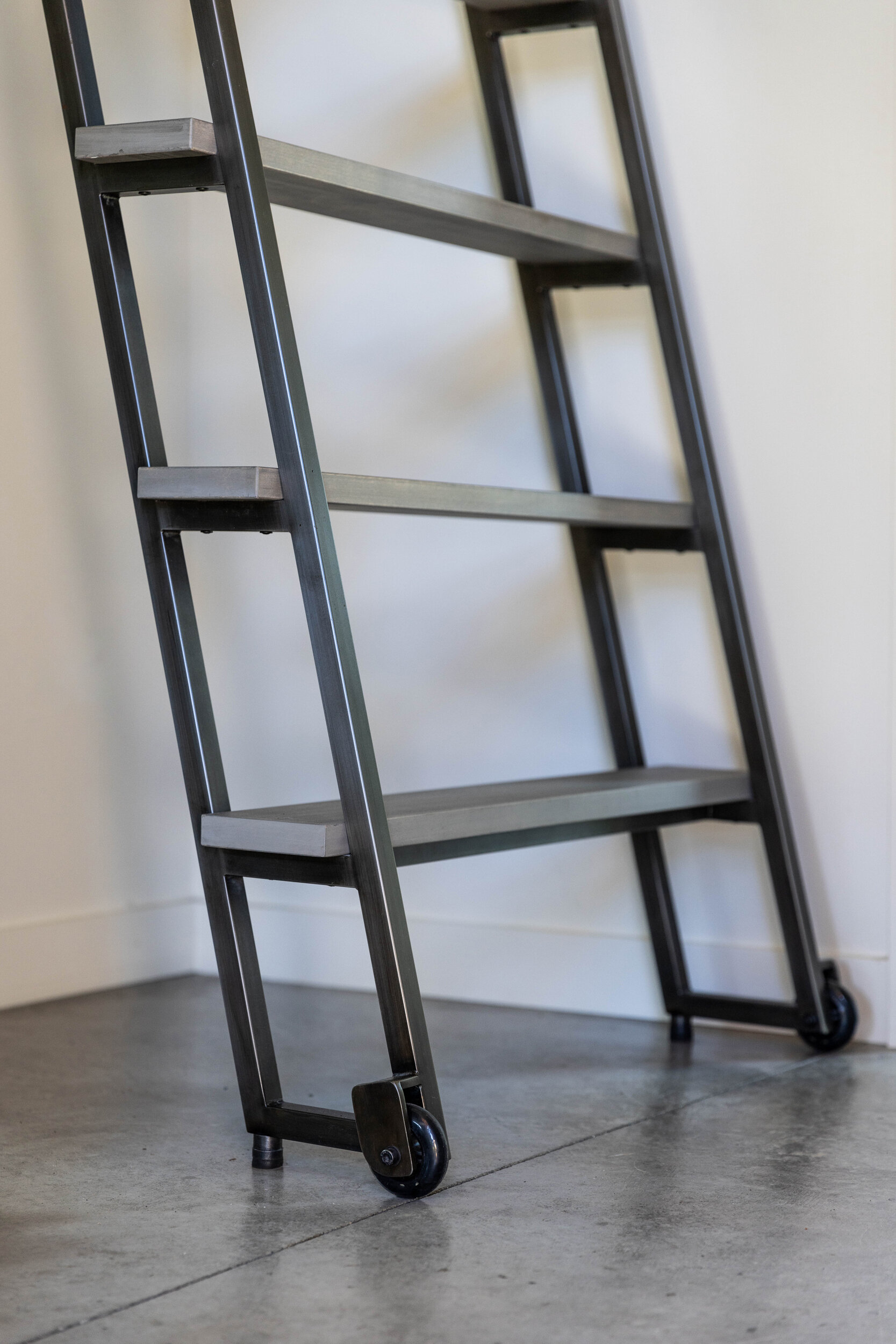 Custom steel ladder leading to a loft that doubles as office and extra sleeping space, adding flexibility for family gatherings and entertaining.