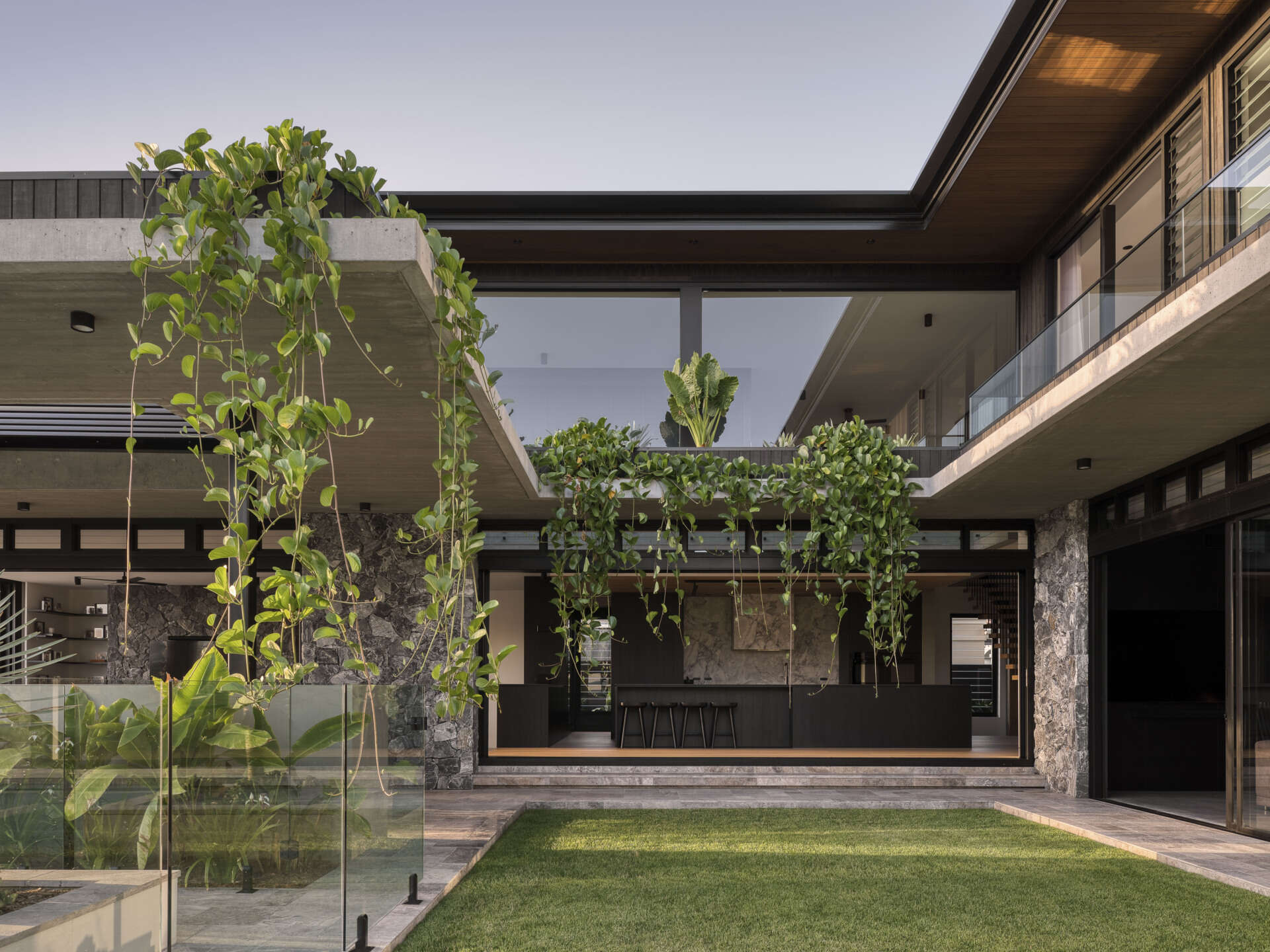 The kitchen as well as the dining area, opens to the central courtyard, making it a bright, social hub. Natural ventilation and daylight ensure the space remains comfortable throughout the day. Layered greenery and thoughtful detailing create a calm, inviting atmosphere where family meals feel connected to the surrounding landscape.