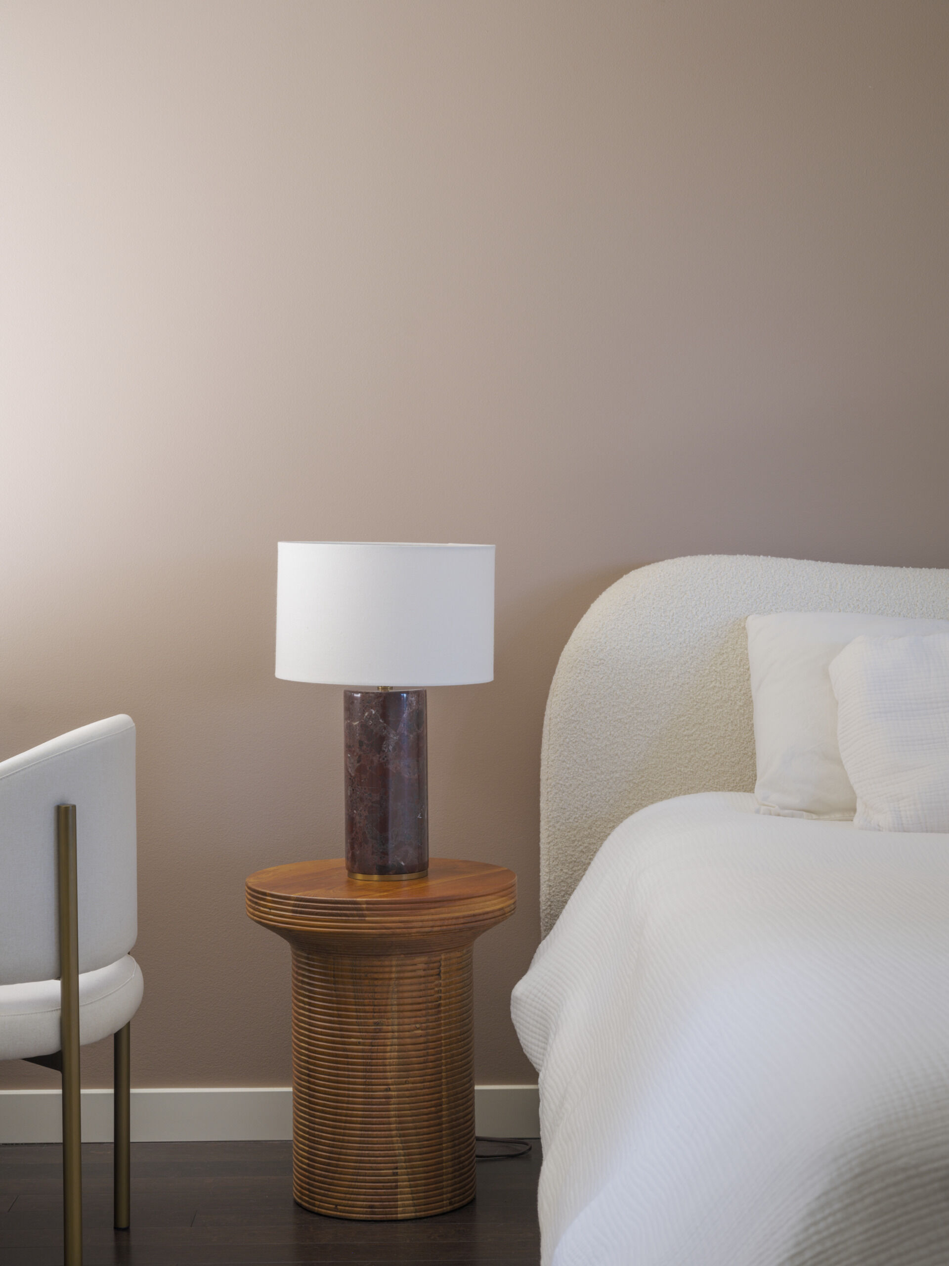This bedroom is neutral in its appearance, with soft curves and comfortable furnishings