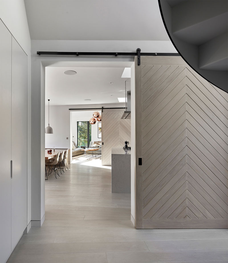 A sliding barn door connects the entry hall to the main living spaces, blending rustic and modern touches.