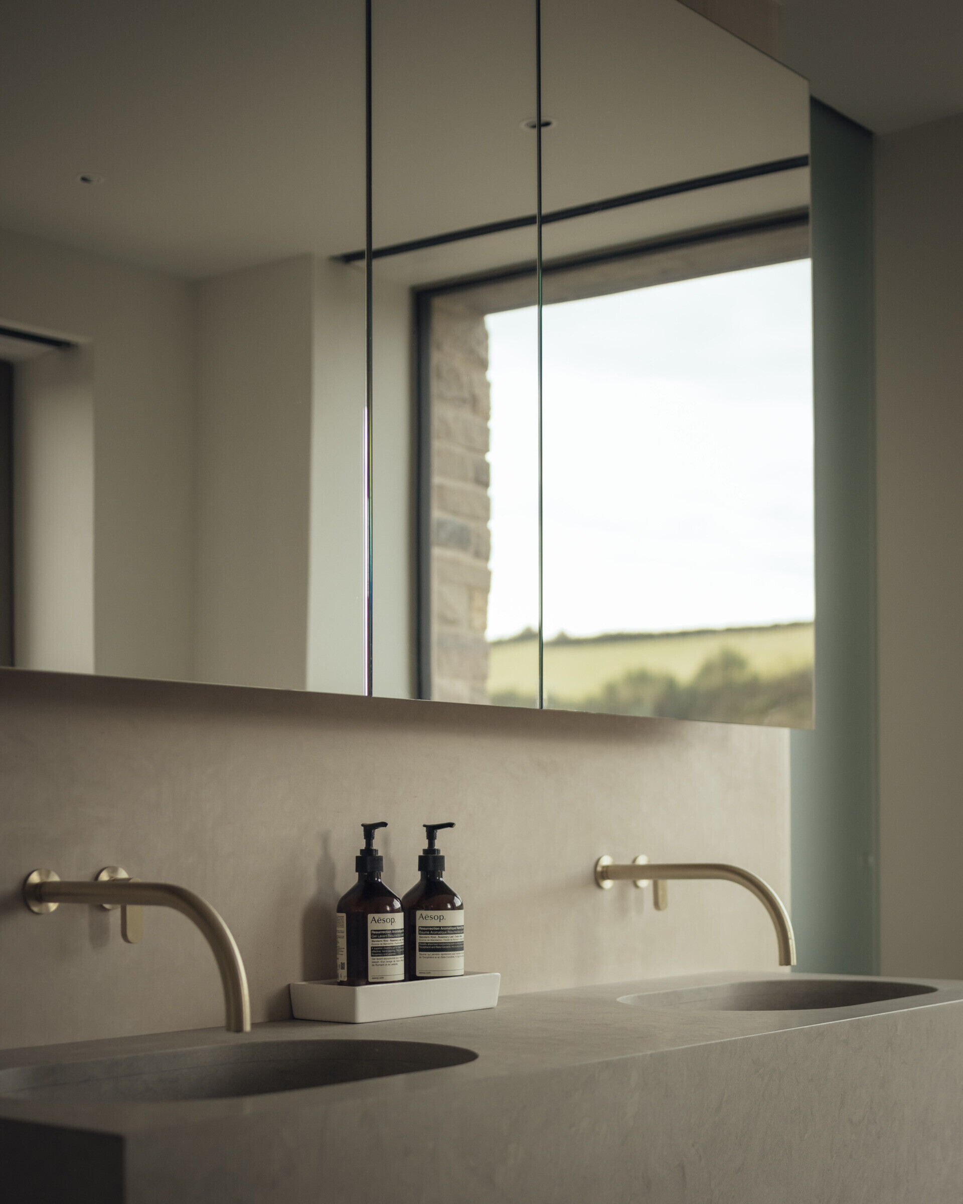 A modern bathroom with a freestanding bathtub, a large window and a double vanity.
