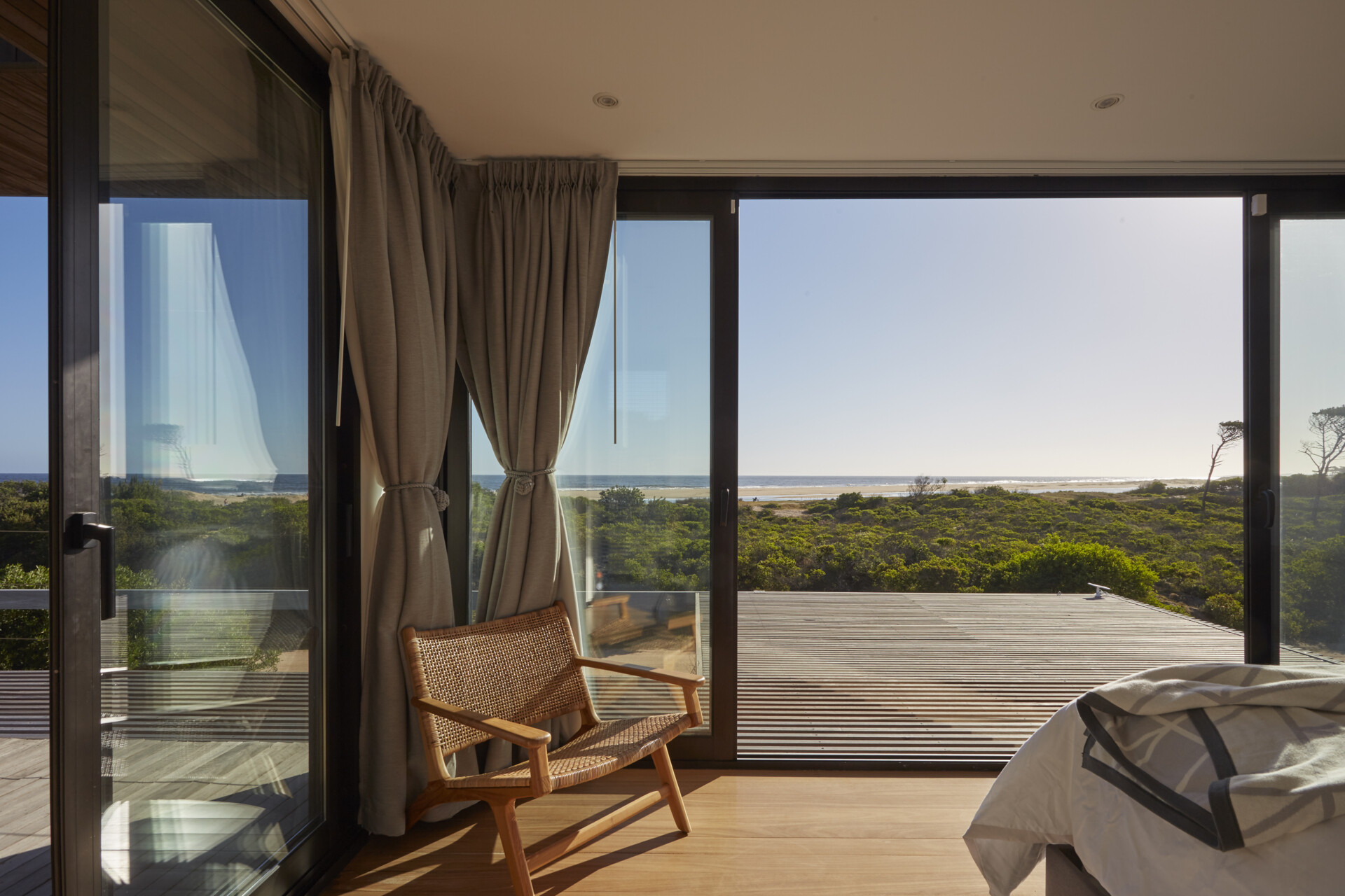 The home includes several bedrooms across the modules, each with an en suite bathroom. The upper module contains the primary suite, complete with a dressing room, a fully compartmentalized bathroom, and a private outdoor terrace facing the ocean.