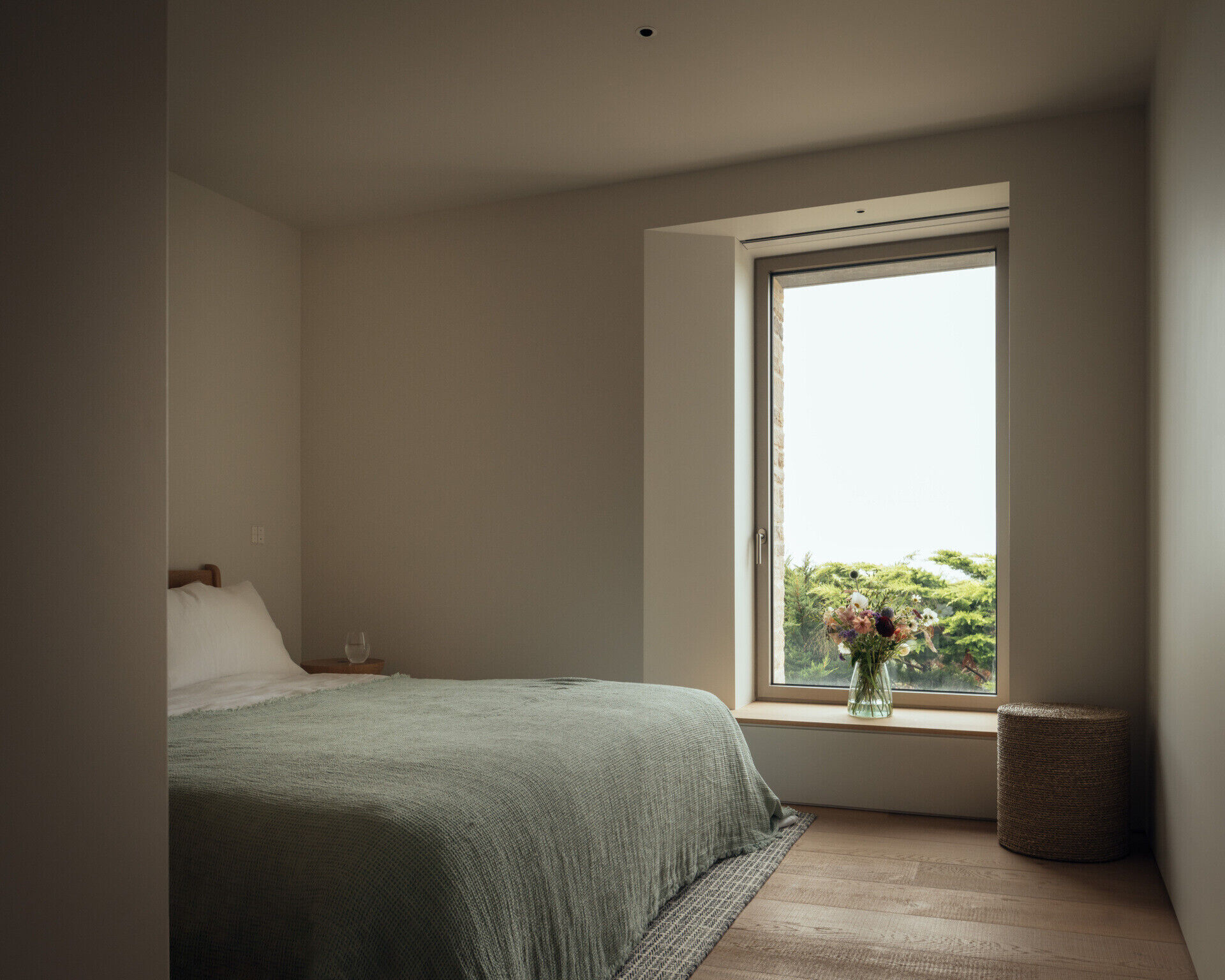 A modern bedroom with a window that frames the view.