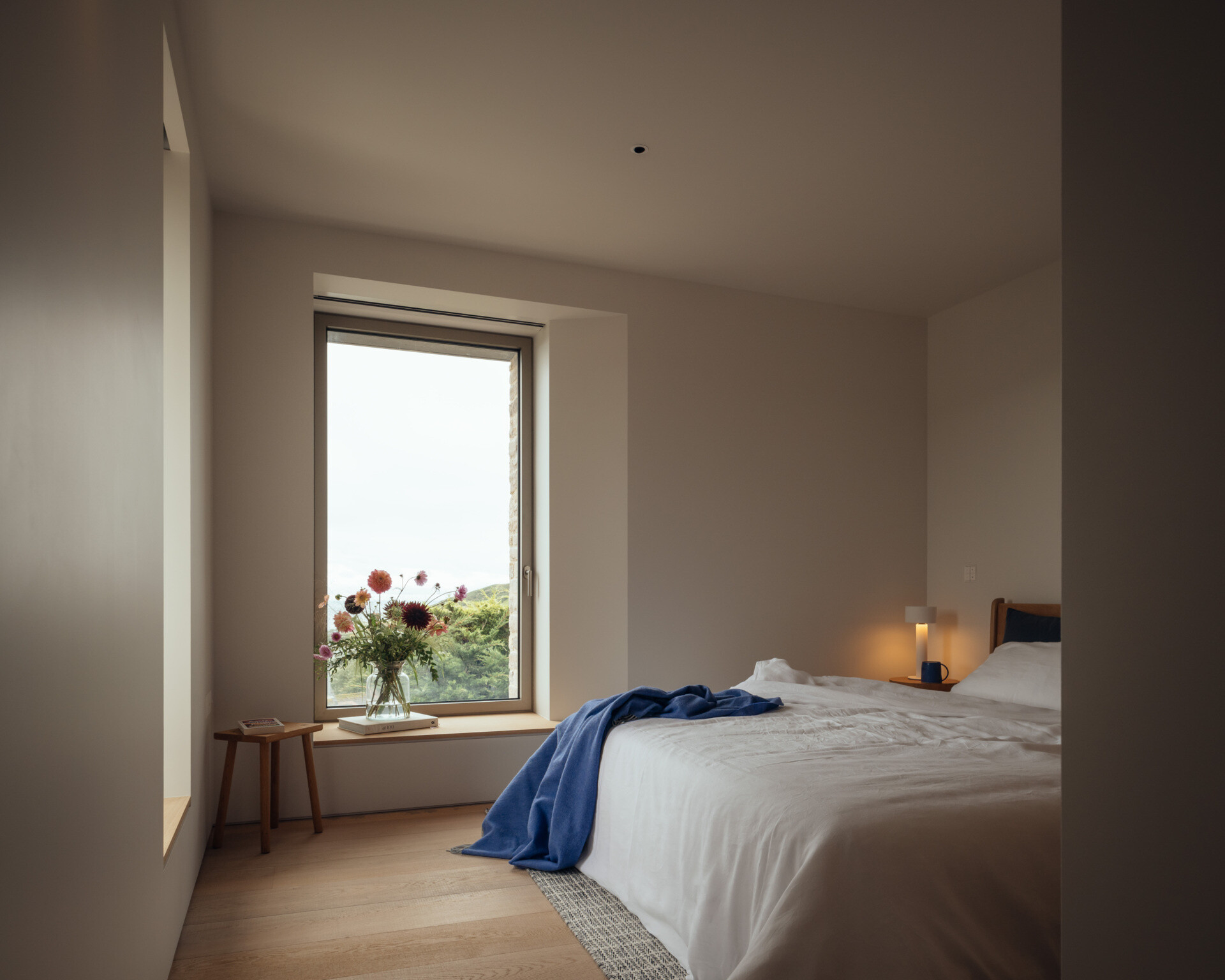 A modern bedroom with a window that frames the view.