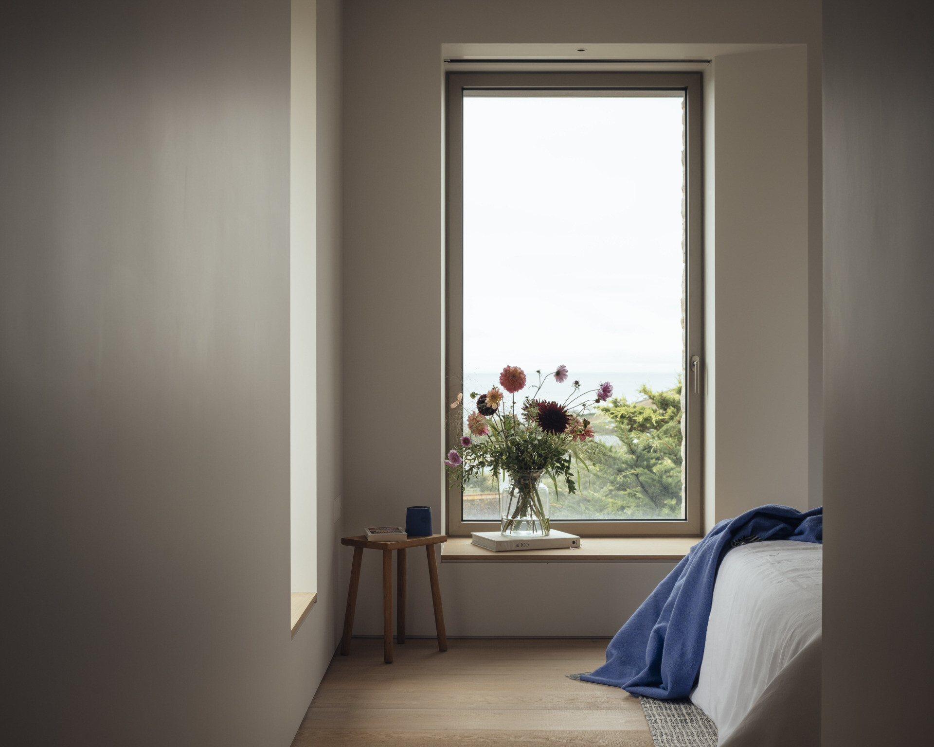 A modern bedroom with a window that frames the view.